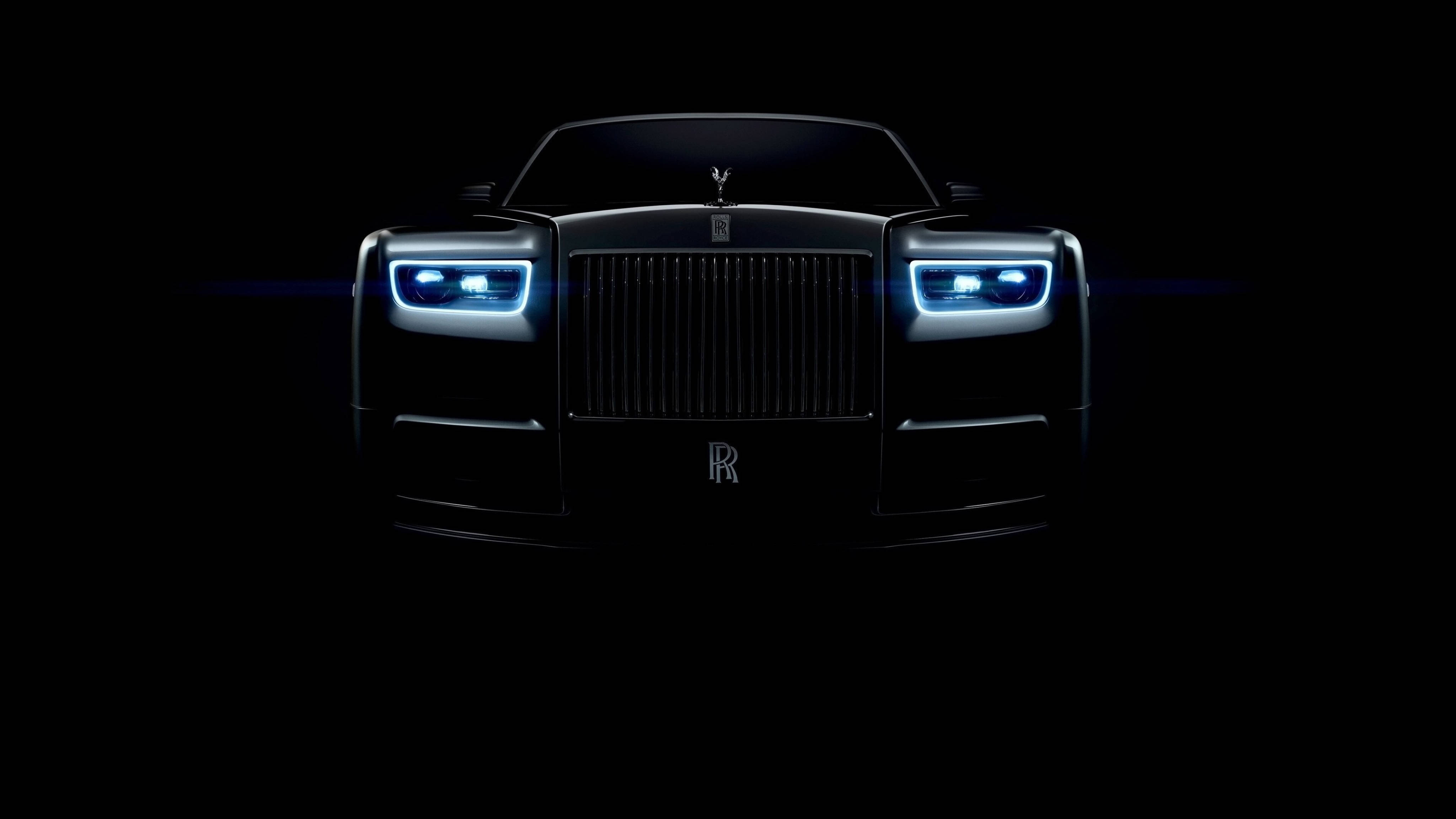 勞斯萊斯汽車全4K壁紙 壁紙 — 勞斯萊斯Phantom正面視圖，由發光的藍色車頭燈照亮，背景漆黑一片。