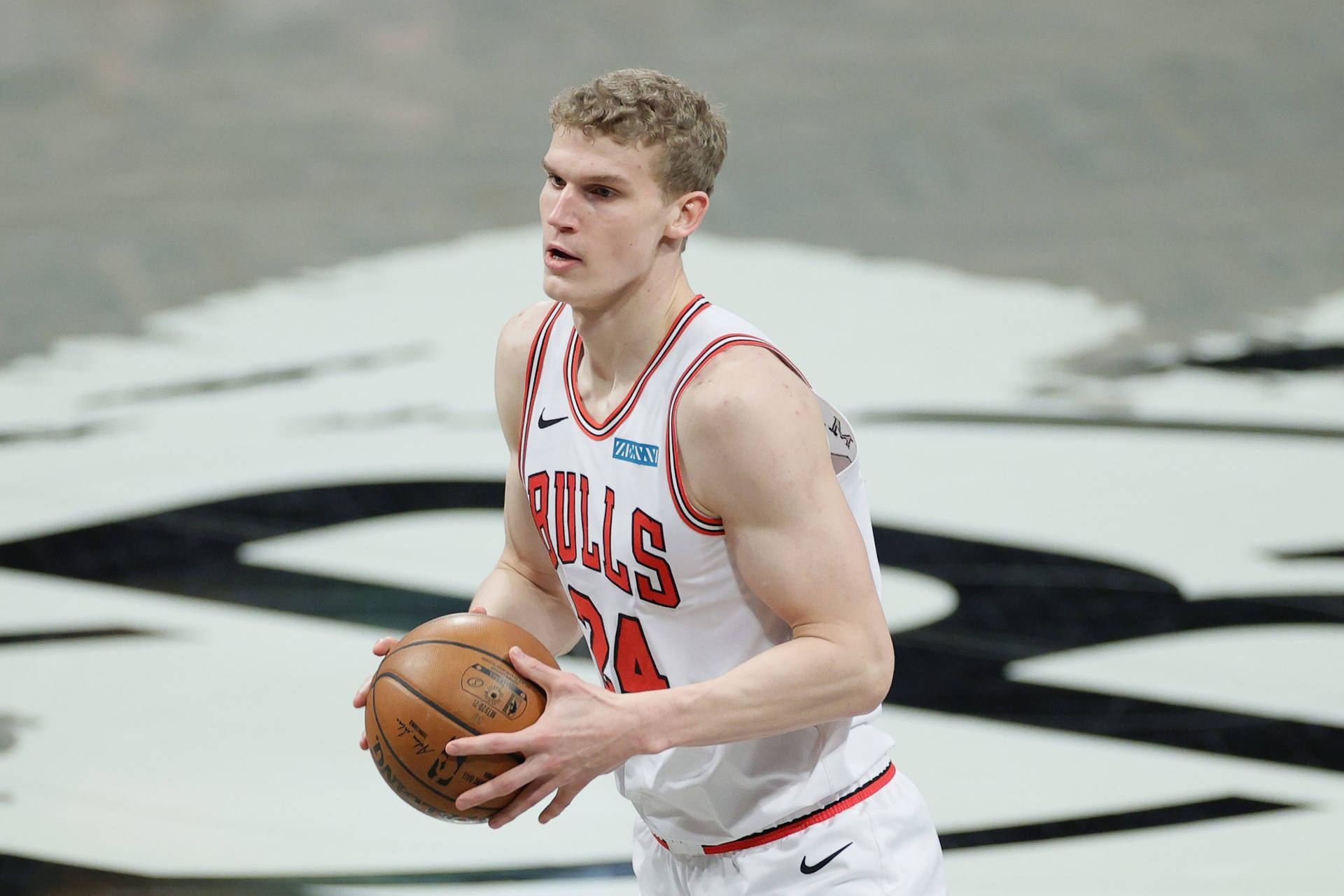 身穿公牛隊球衣的籃球運動員在比賽中運球。