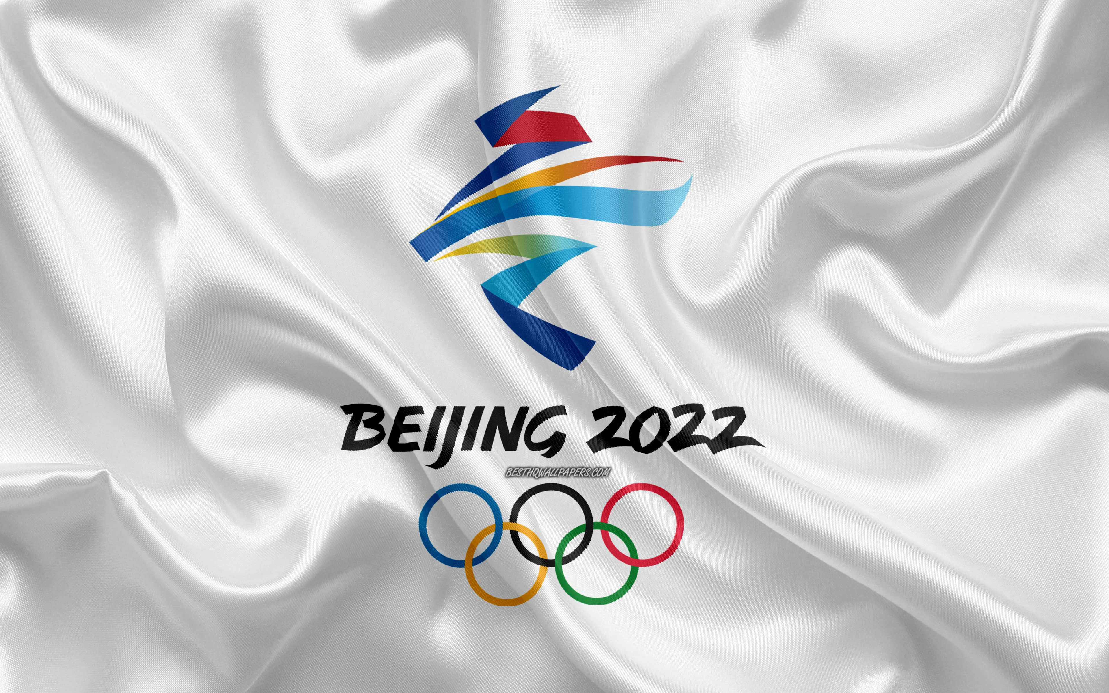 Winter Games 桌布 壁紙 — 北京2022年冬季奧運會標誌和五環展示在飄逸的白色緞面布料上，帶有鮮豔的色彩點綴。