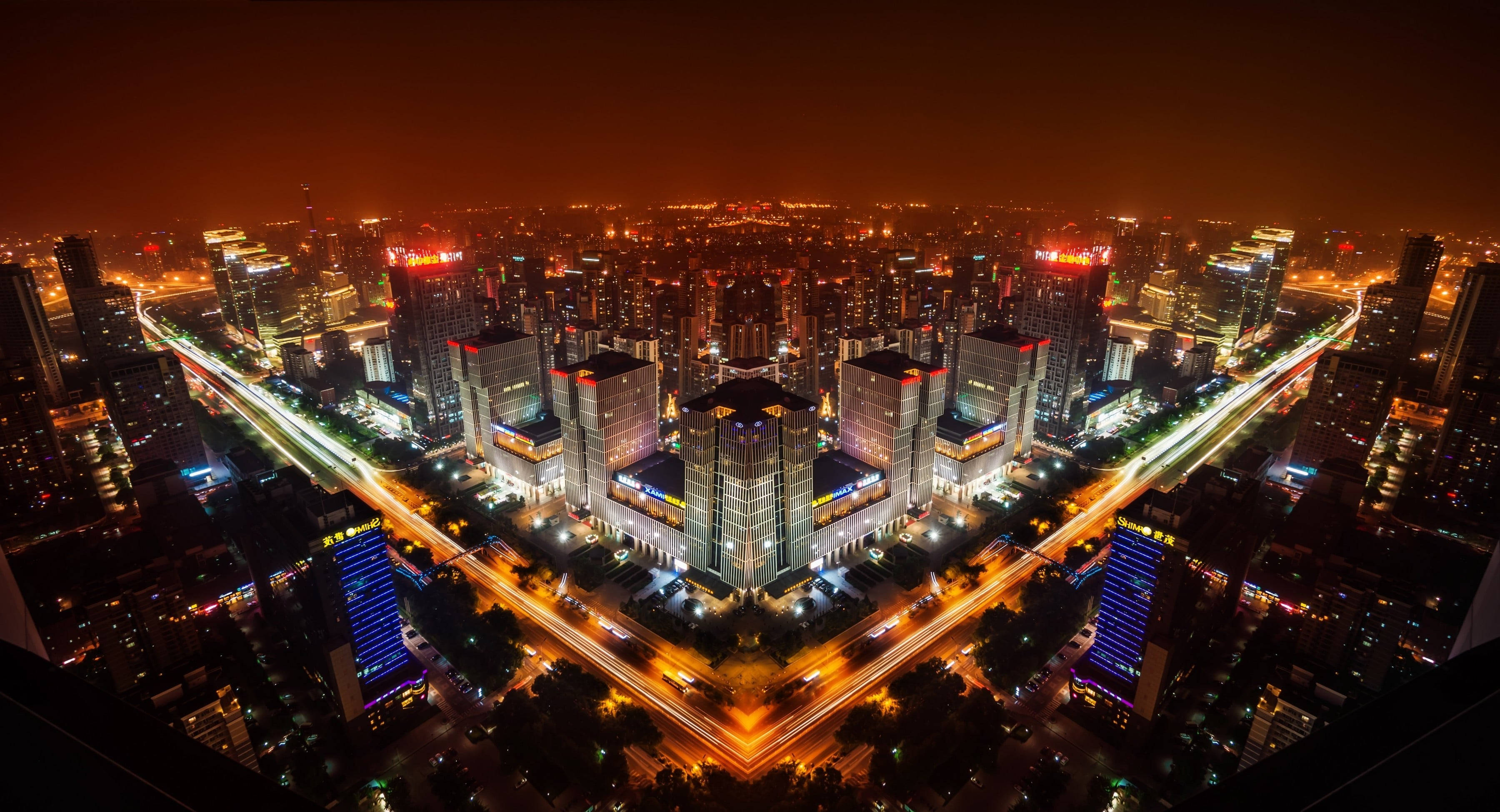 北京夜景 壁紙 — 廣闊城市景觀的夜間航拍，閃爍的摩天大樓和車流形成的光跡。