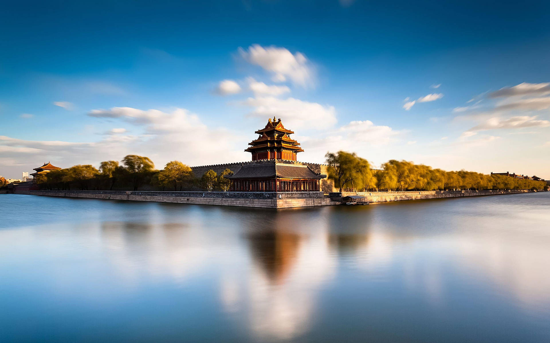 古代中國宮殿塔樓在明亮藍天下靜止的水中倒映。