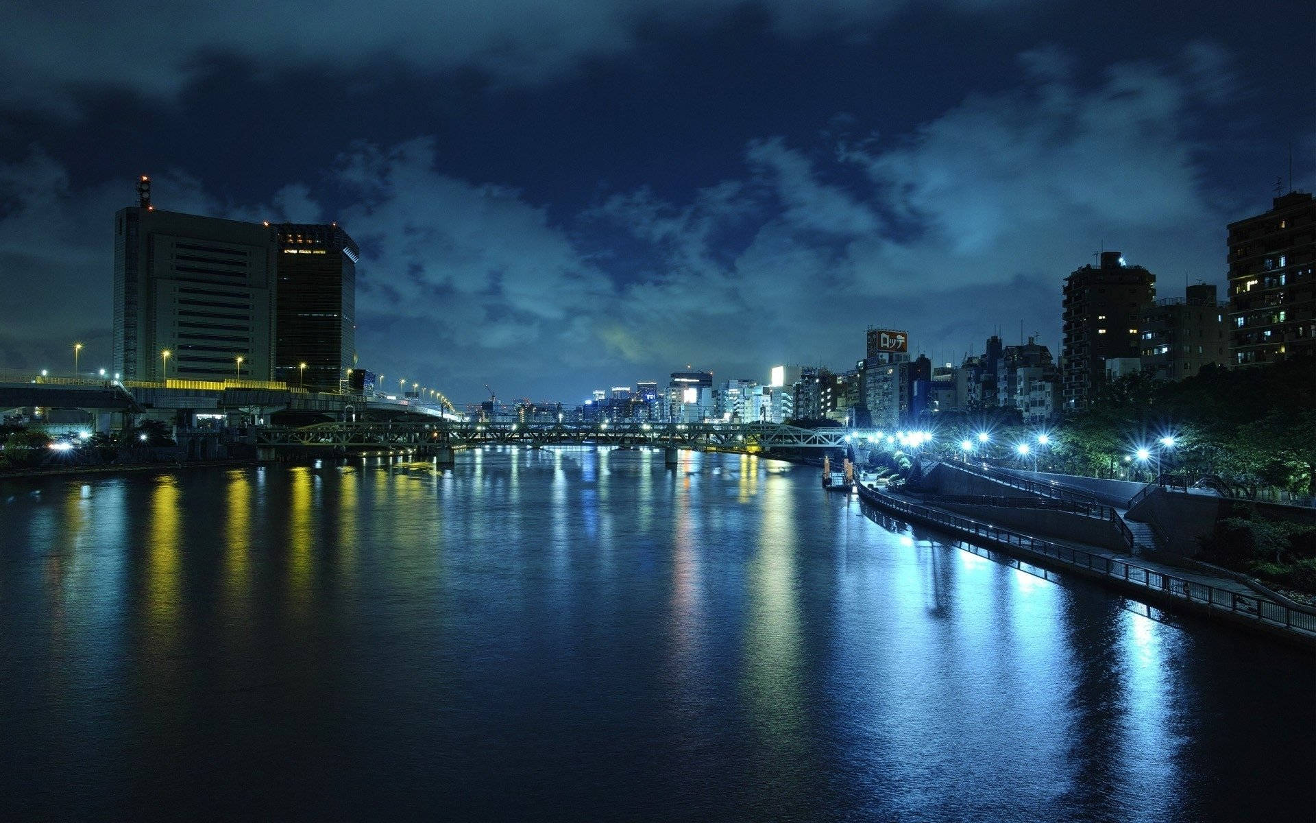 夜間城市天際線，河流反射街燈和建築物燈光。