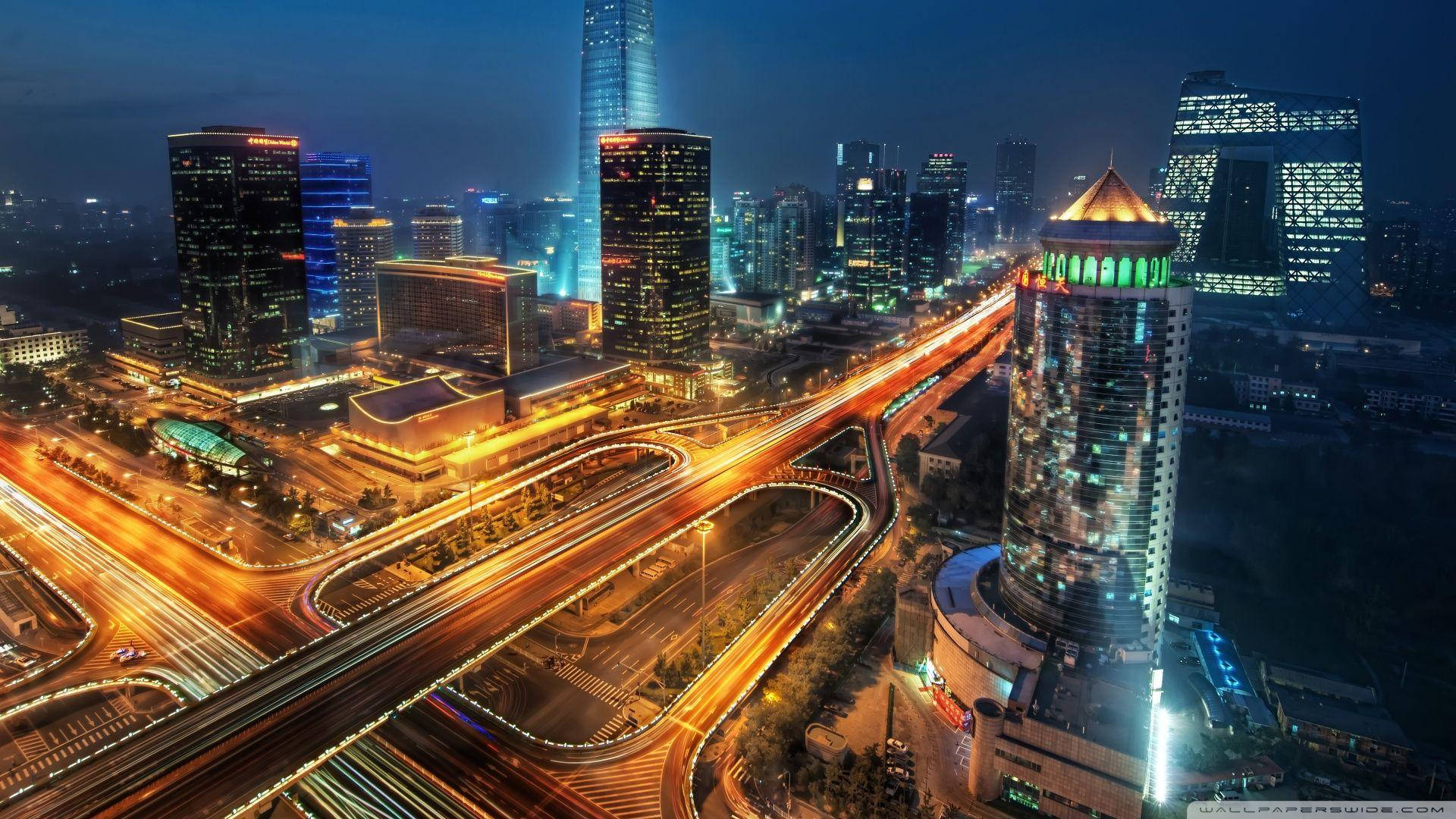 夜間城市景觀，燈火通明的建築物和車輛光跡。