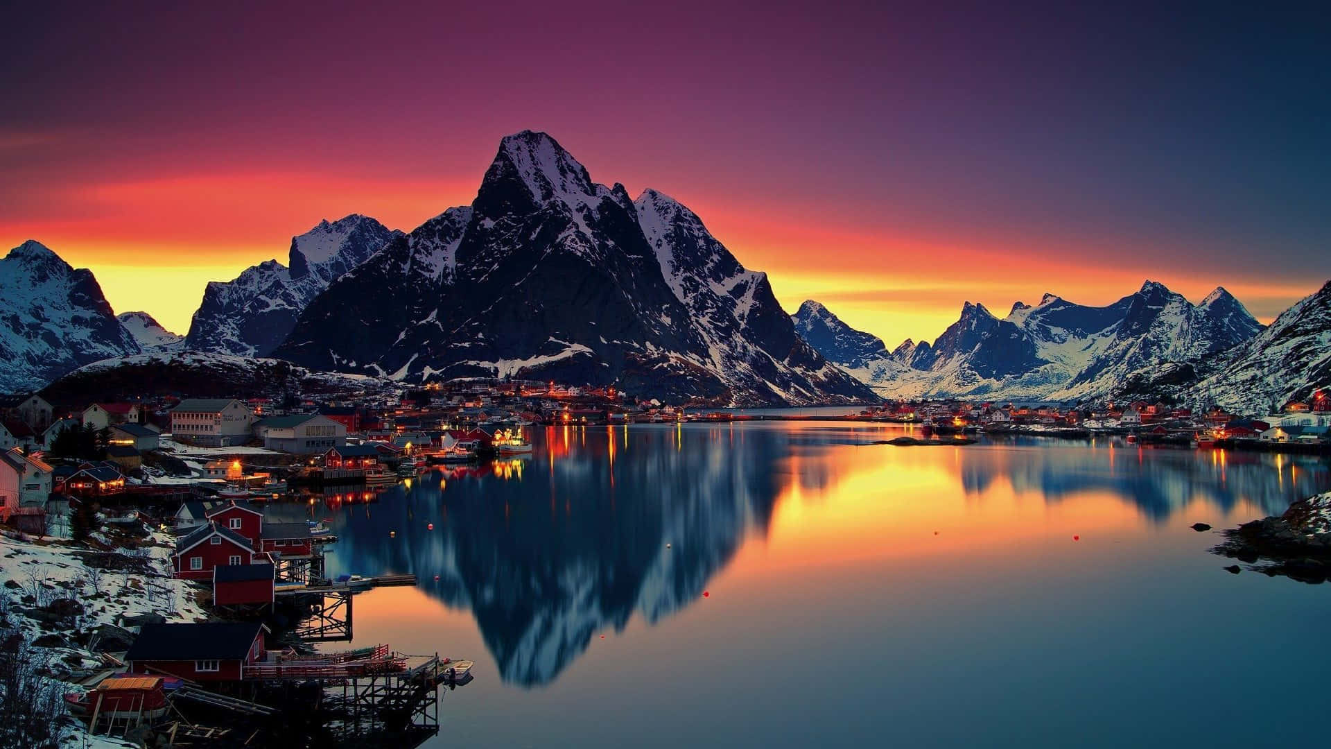 沿海村莊，紅色的房屋坐落在雪山之間，夕陽時分。