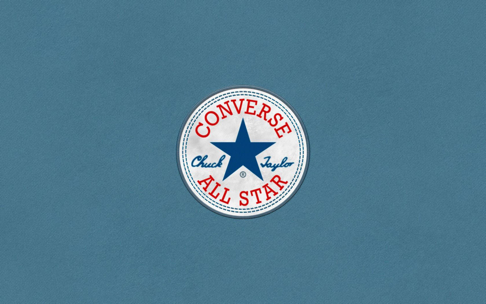 匡威標誌藍色背景 壁紙 — 經典 Converse Chuck Taylor All Star 標誌居中於有紋理的藍色布料背景上。