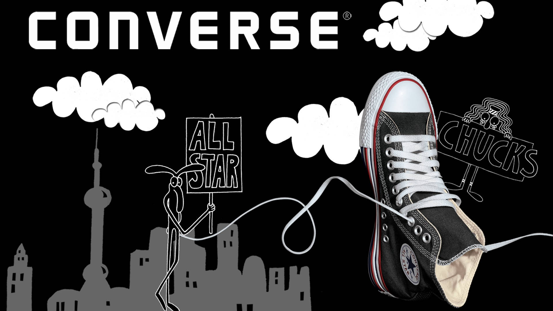 匡威標誌藝術創作 壁紙 — 一對黑色Converse Chuck Taylor運動鞋漂浮在黑色背景上，有白色雲朵和卡通人物舉著寫有「ALL STAR」和「CHUCKS」的標語牌，上方是灰色的城市天際線。