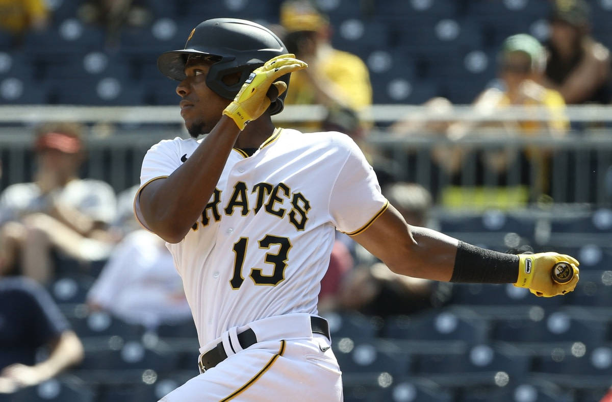 身穿 Pirates 球衣的棒球選手在日間比賽中調整頭盔。