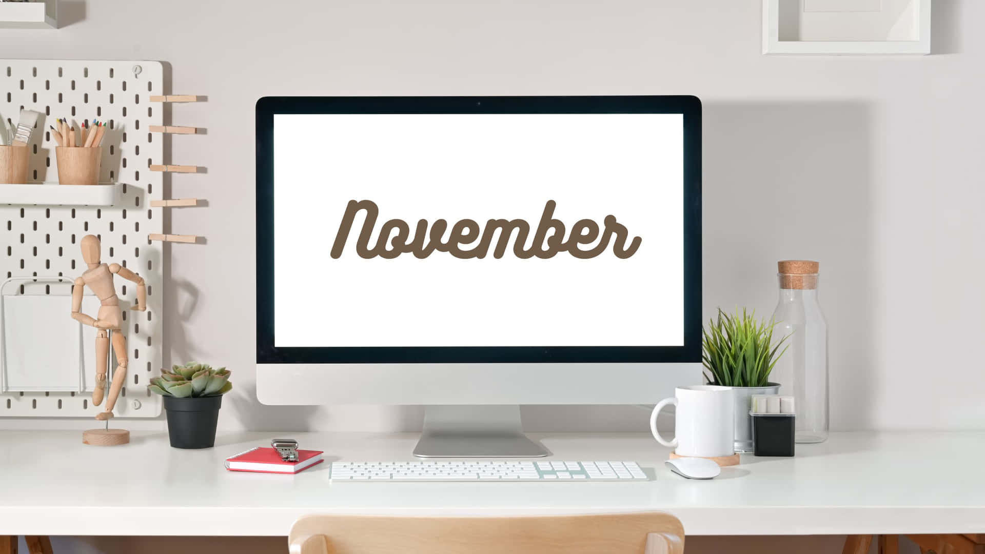 一個乾淨的白色桌面，電腦顯示November、植物和辦公用品。