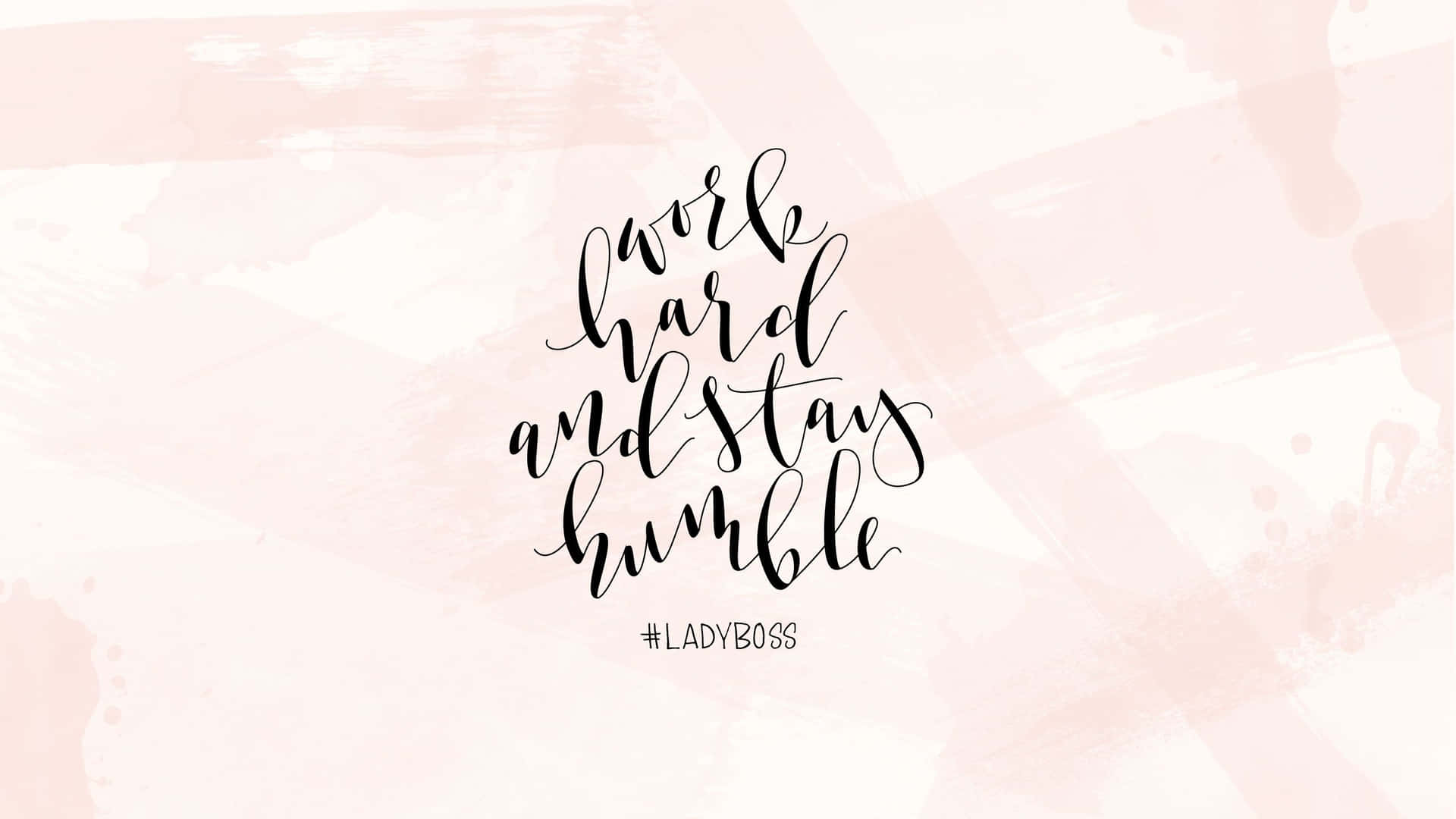 粉紅色水彩背景上黑色字體的勵志名言「work hard and stay humble」