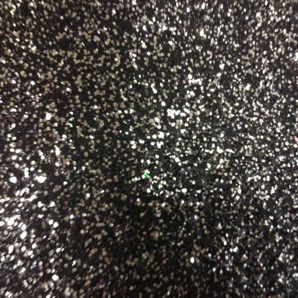黑色閃粉的特寫，銀色和白色閃光反射光線。