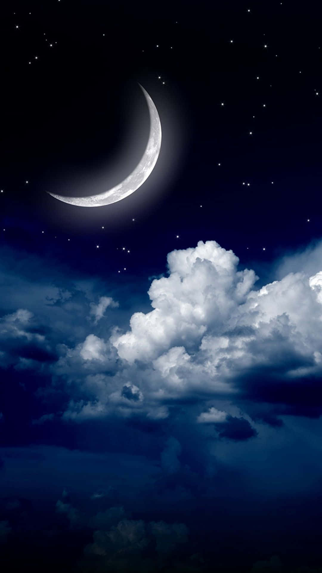 彎月在繁星點點的夜空中照耀在蓬鬆的雲層之上。