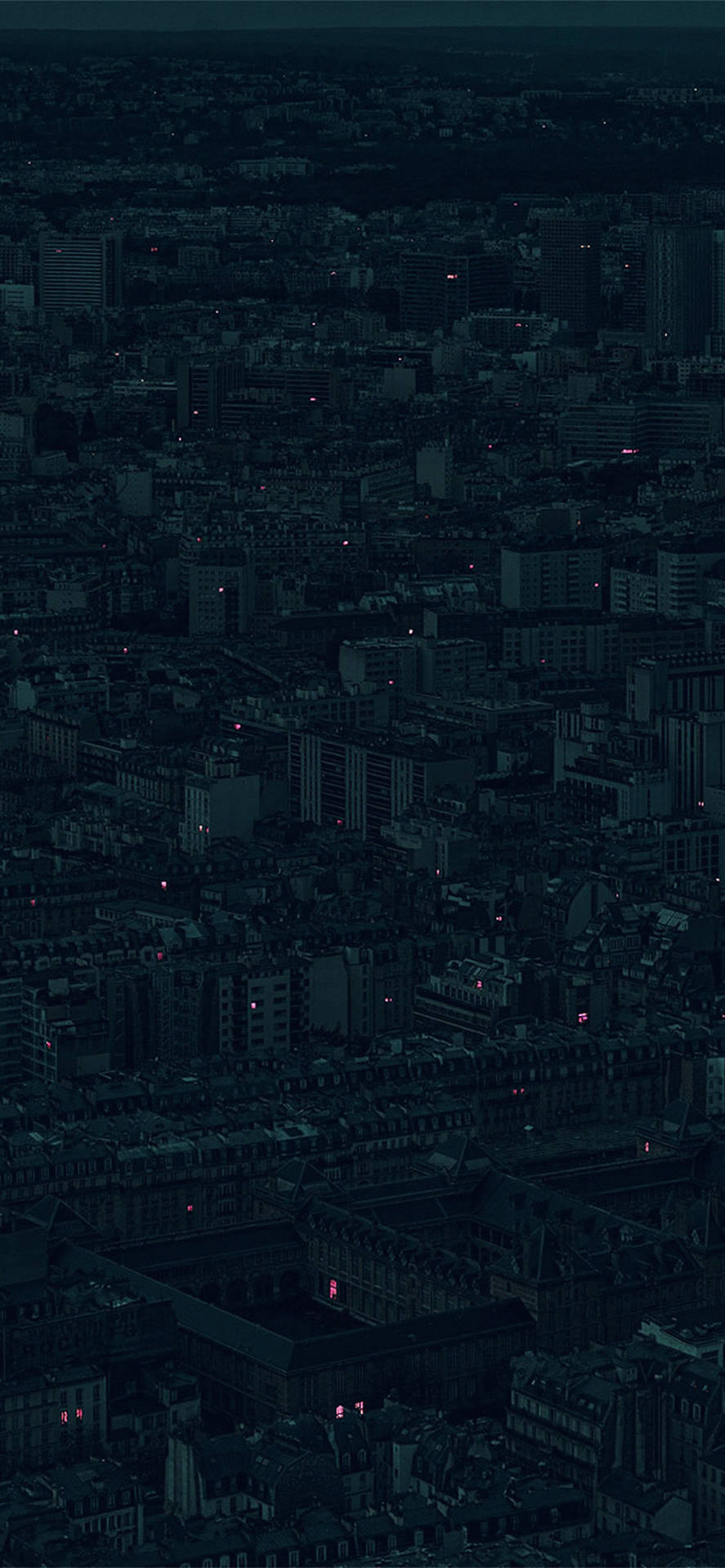密集城市的夜間俯瞰圖，散落著發光的窗戶。