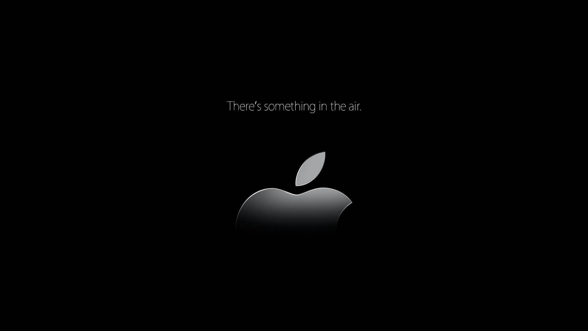 Apple標誌帶有文字There's something in the air在黑色背景上