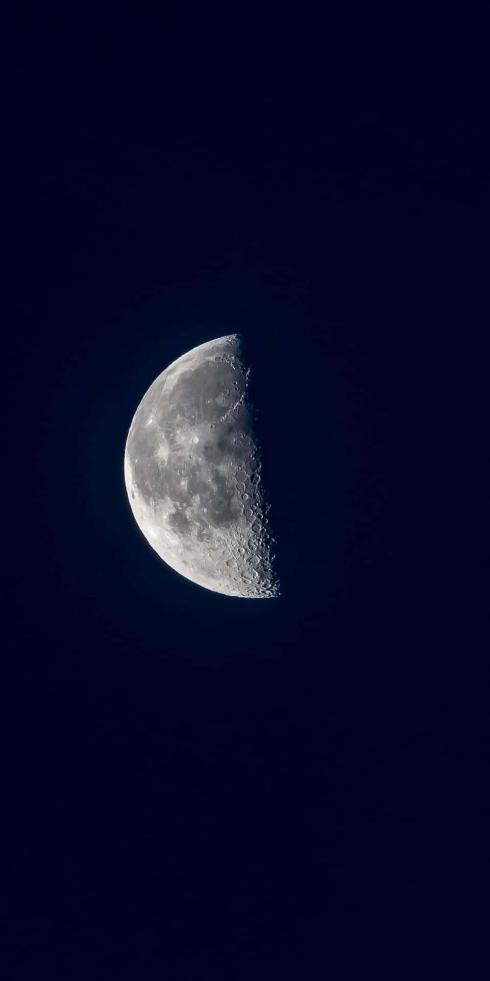 在黑暗夜空中可見隕石坑的彎月