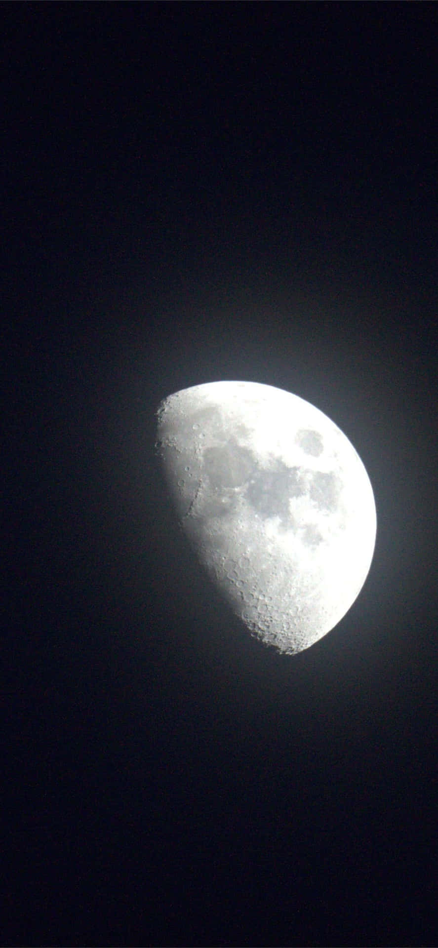 在黑暗的夜空中，一輪明亮的彎月帶有可見的隕石坑。