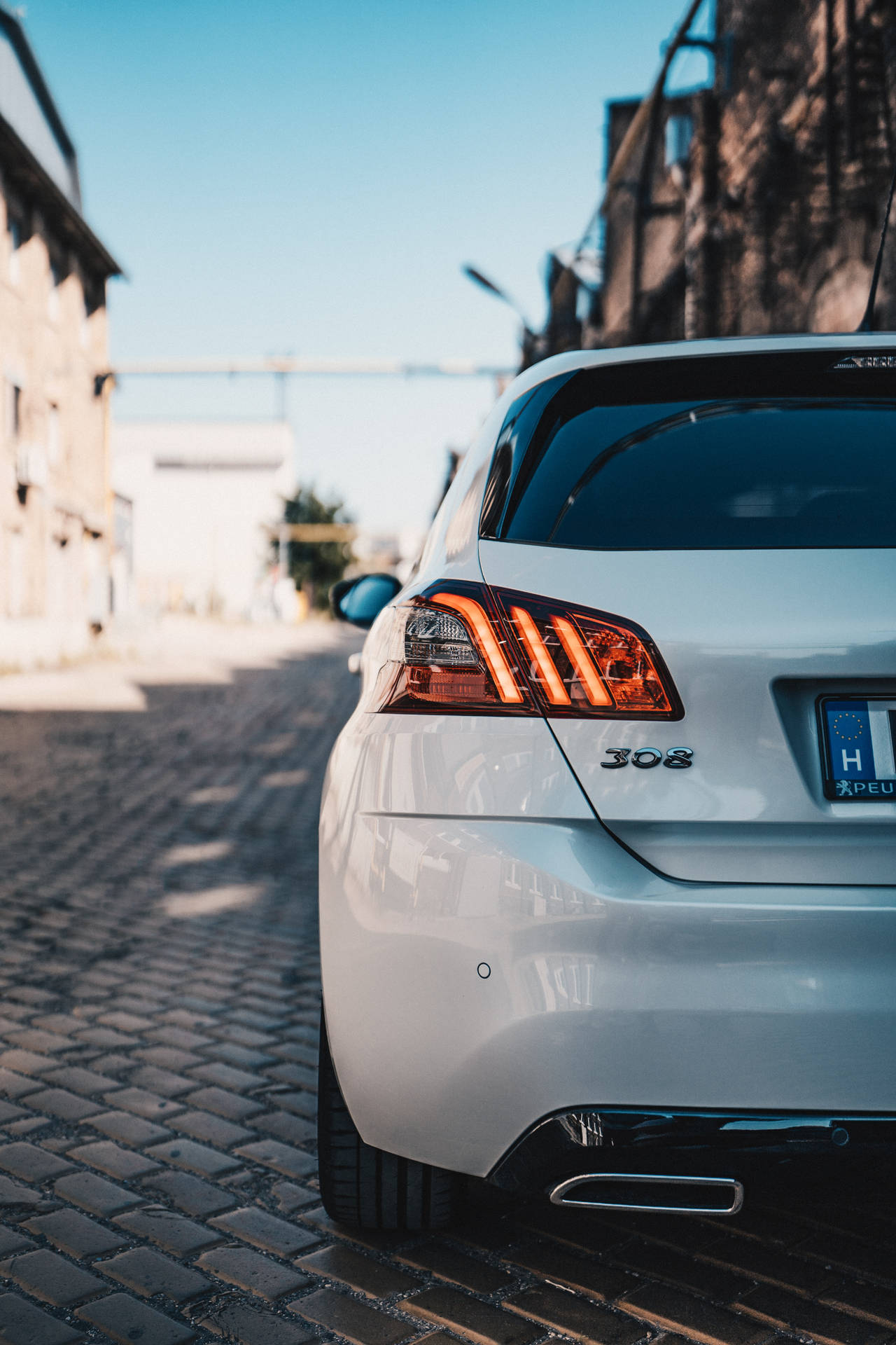 日落時白色Peugeot 308停泊在鵝卵石街道上