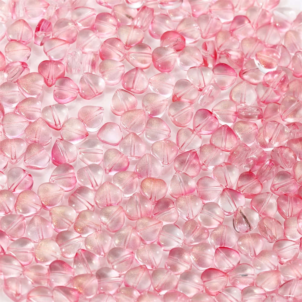 Pink Girly 桌布 壁紙 — 半透明粉紅色心形珠子的特寫，帶有閃亮亮片，密集散佈。