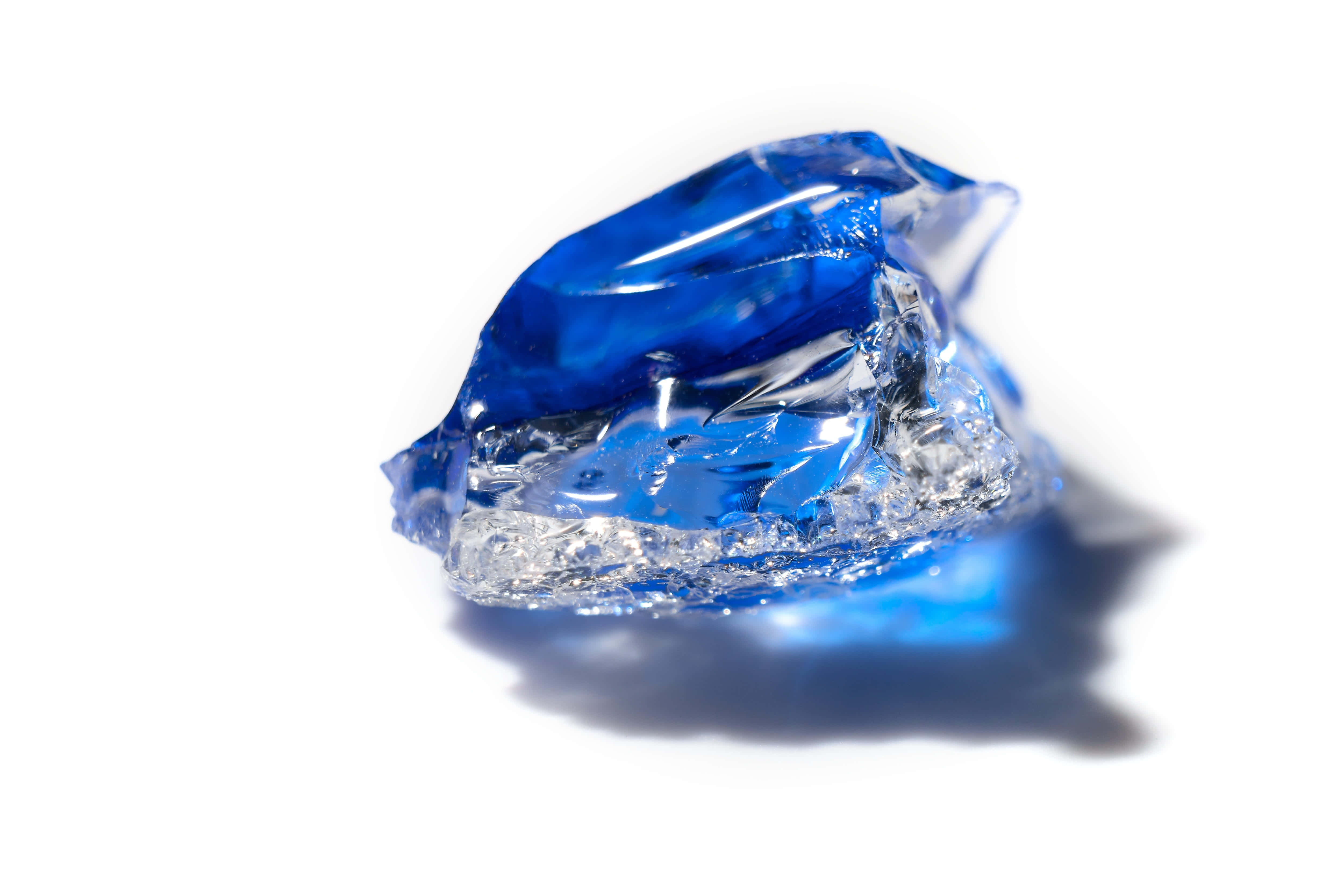 Sapphire Blue 桌布 壁紙 — 半透明藍色凝膠狀晶體，邊緣呈鋸齒狀，在純白背景上投下柔和陰影。