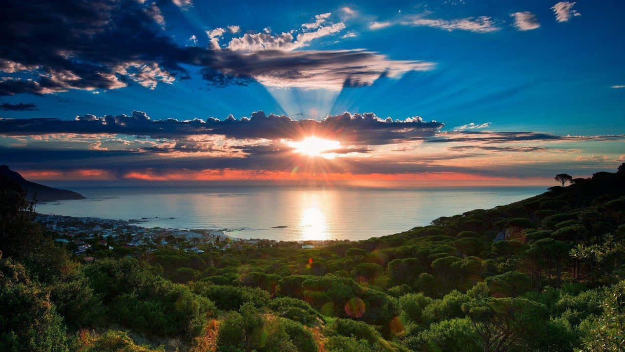 海岸小鎮的夕陽，有翠綠山丘和海洋
