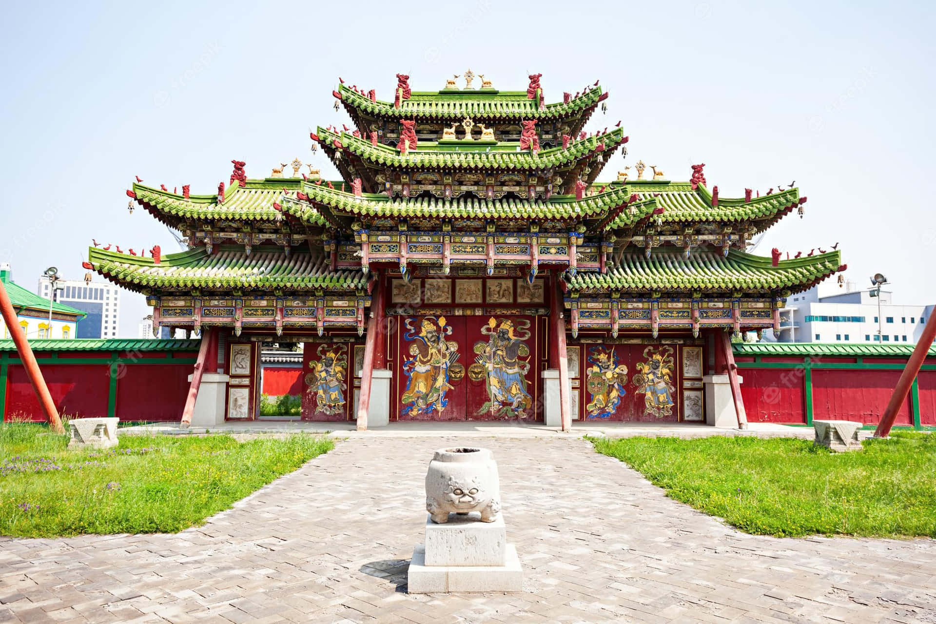 傳統中國寺廟，綠色屋頂和紅色柱子，前景有石獅雕像。