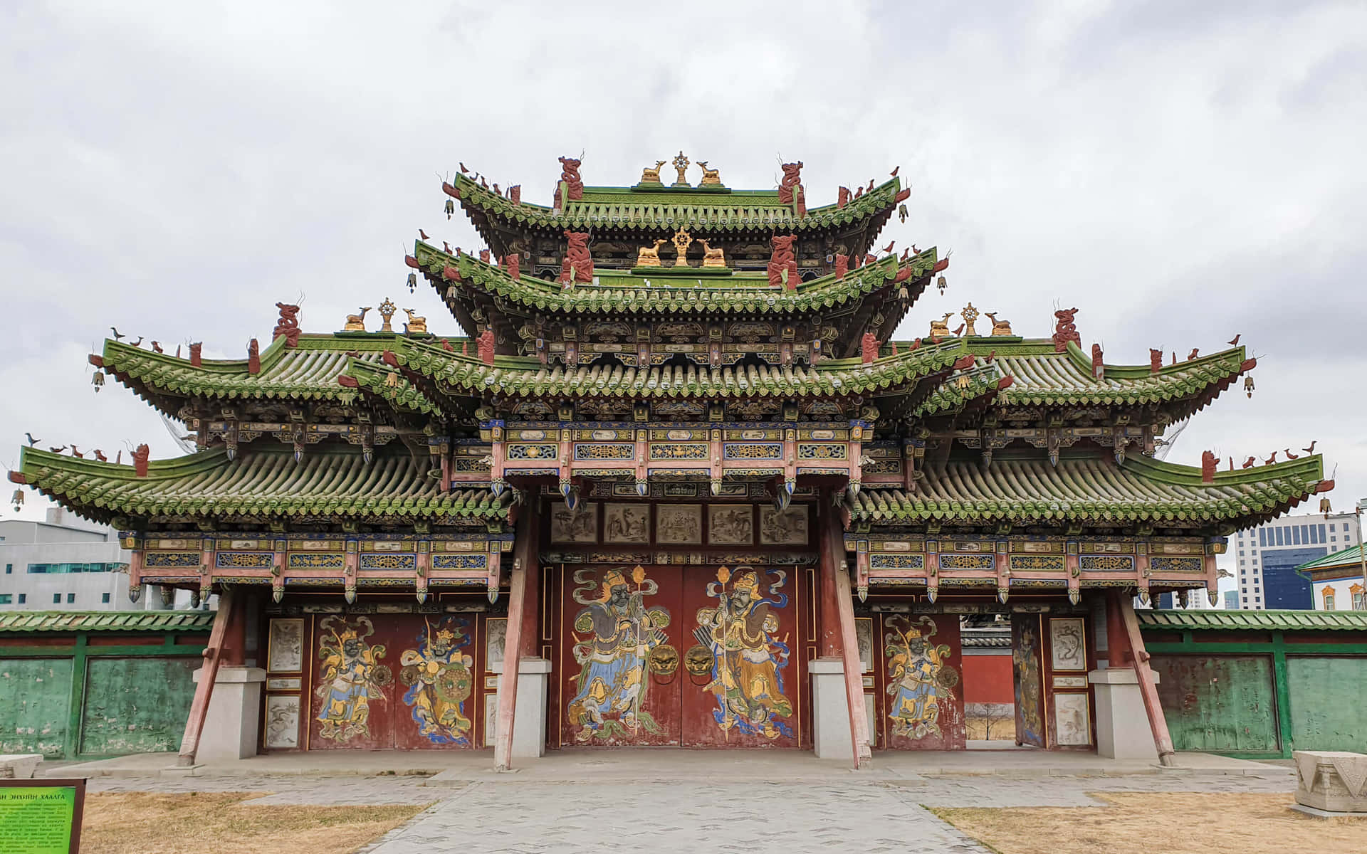 宏偉的傳統中式寺廟，綠色屋頂和紅色門上繪有神明壁畫。