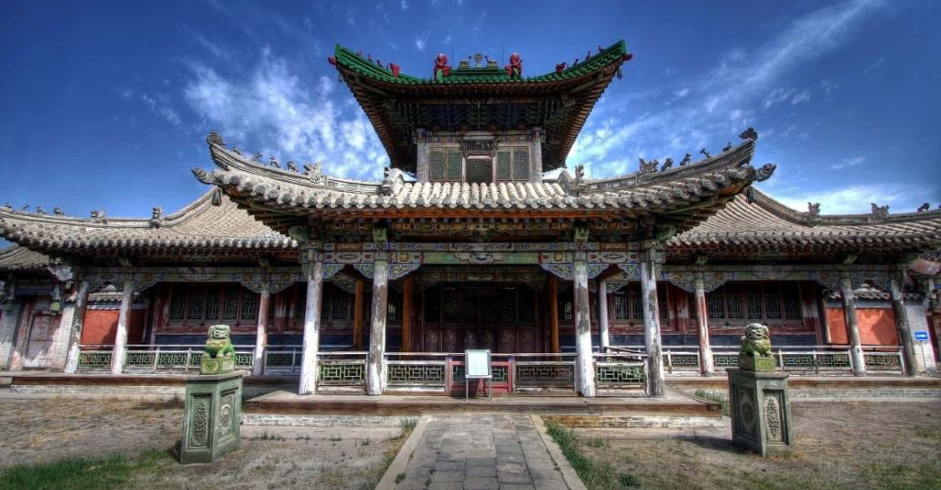 古老的寺廟，擁有彎曲的屋頂和石獅守護者，在清澈的藍天下。
