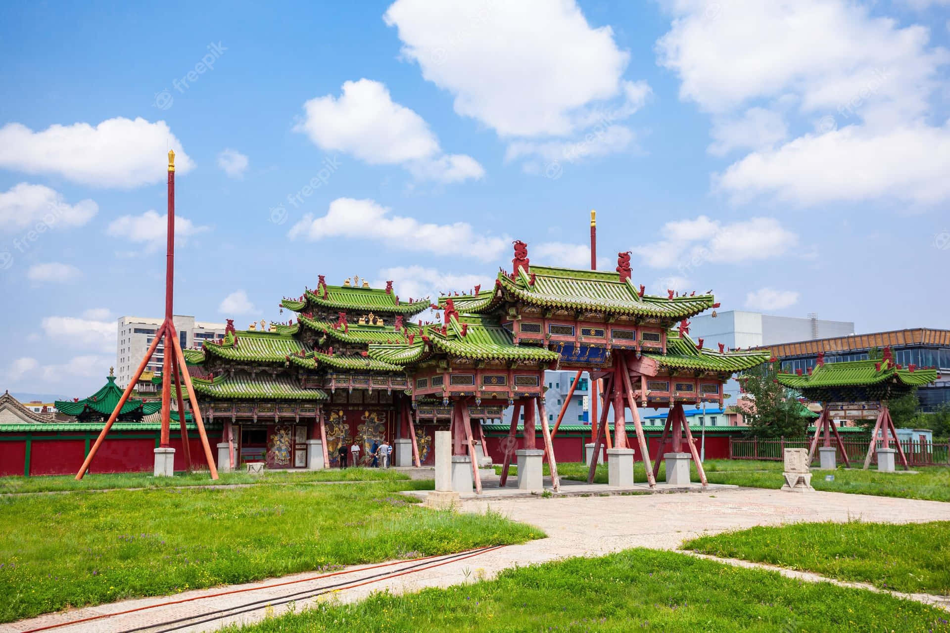 傳統中國寺廟，綠色屋頂和紅色柱子，在藍天白雲下。