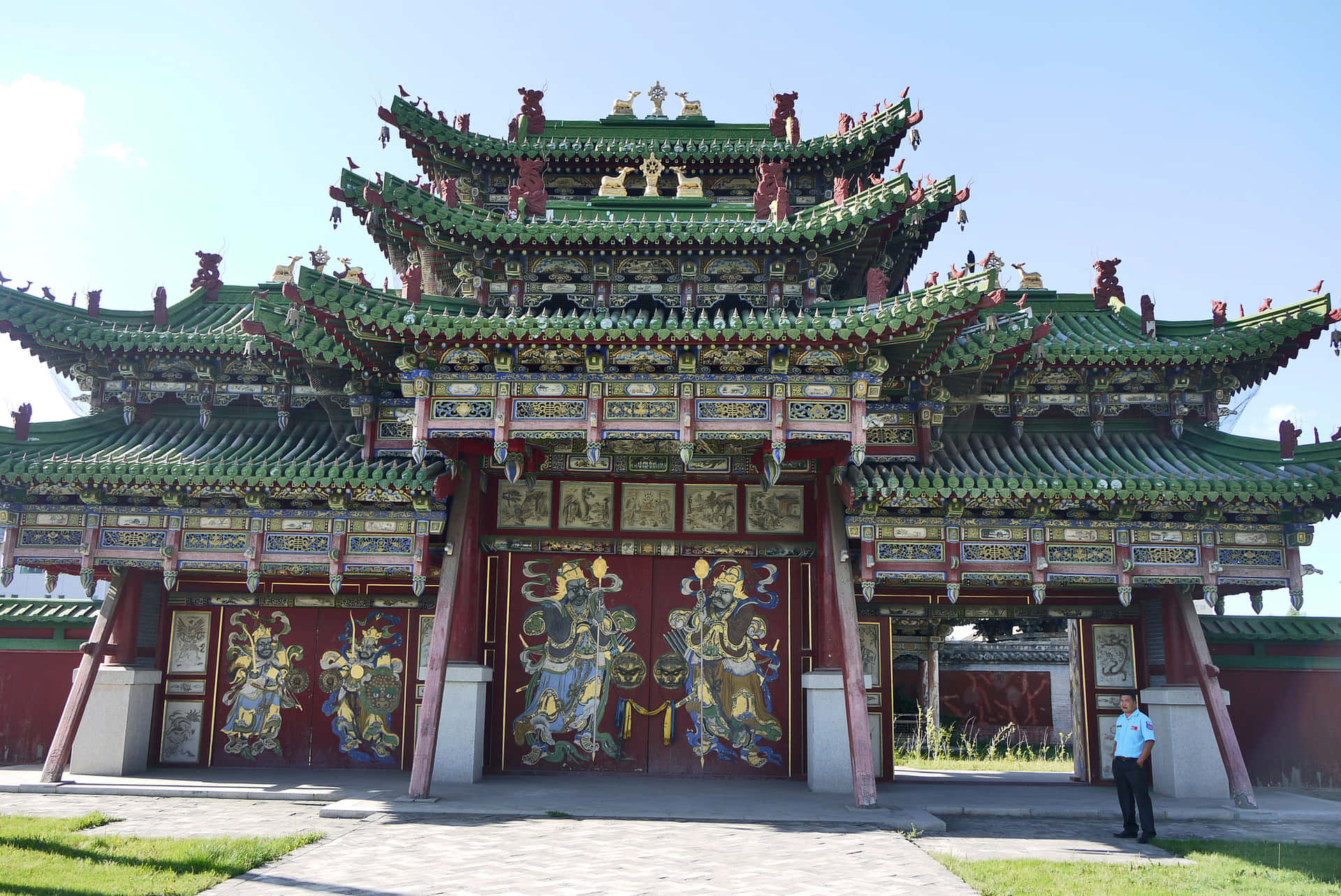 宏偉華麗的中國寺廟大門，帶有守護神壁畫和綠色屋頂。