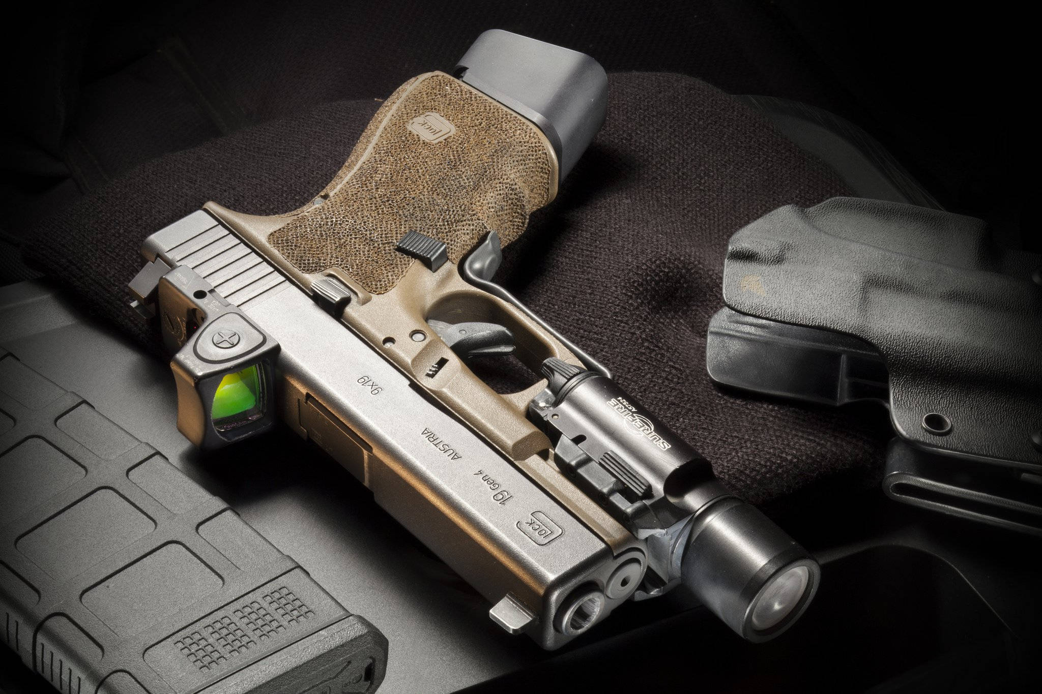卡其色 Glock 19 Gen 4 壁紙 — 一把棕銀色戰術手槍配備激光瞄準器和手電筒，放置在帶紋理的黑色槍套和彈匣上，背景為深色。