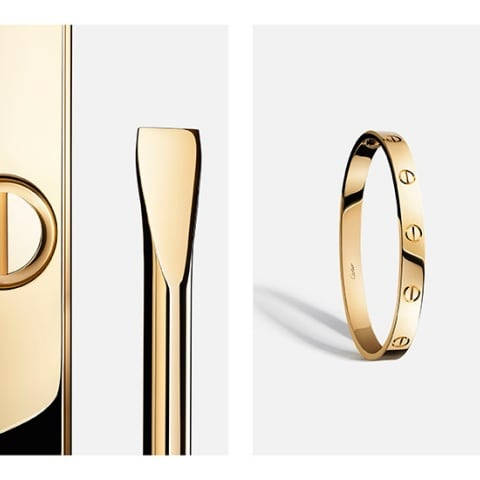 金色 Cartier LOVE 手鐲及標誌性工具在白色背景上。