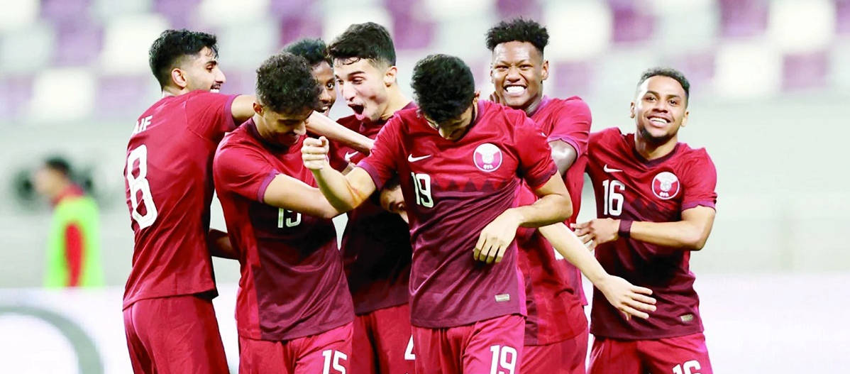 卡塔爾國家足球隊為FIFA世界盃做準備 壁紙 — 一群身穿紅色球衣的足球運動員在燈火通明的球場上熱烈慶祝。