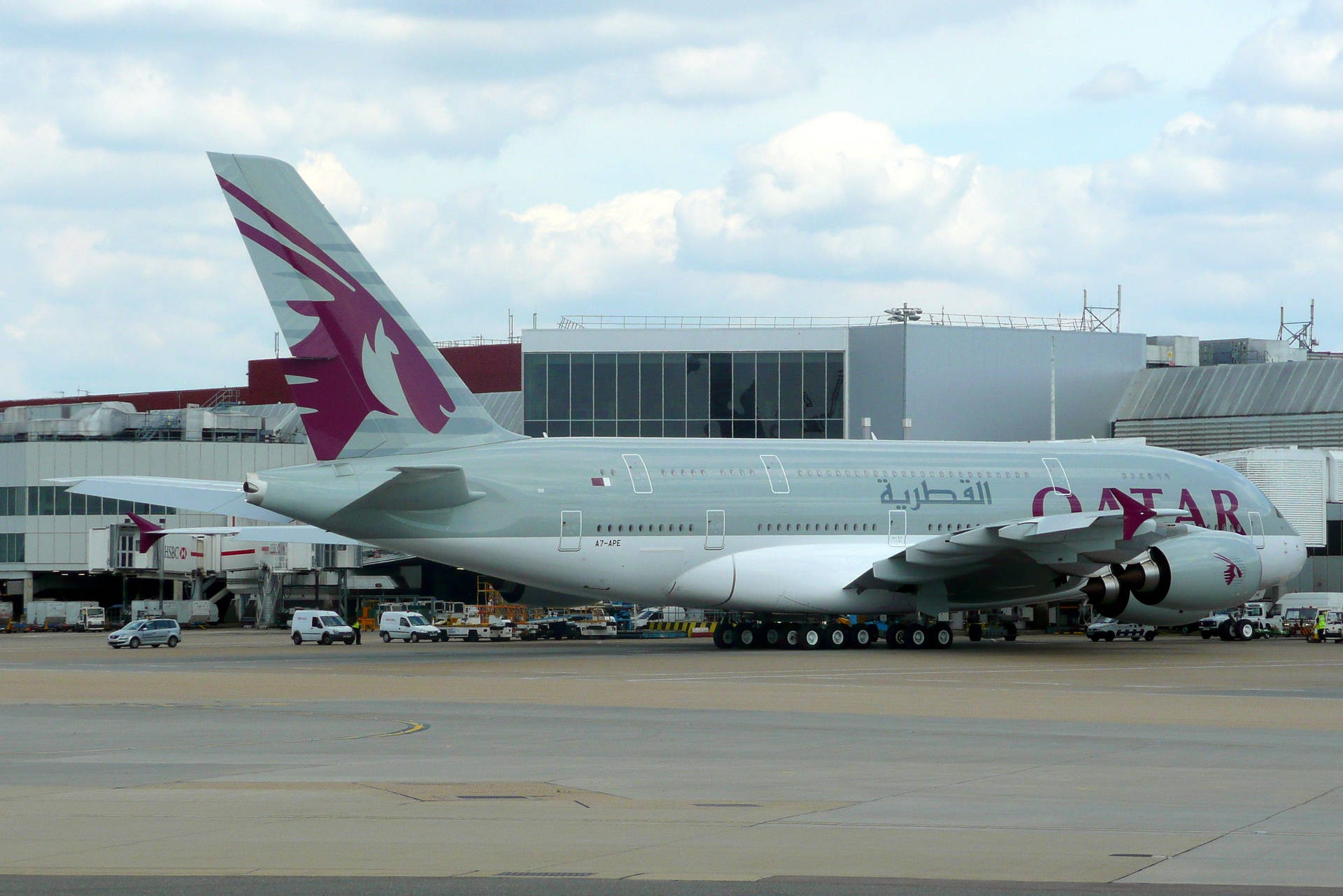 卡塔爾航空A380飛機停泊在機場閘口，旁邊有地勤車輛。