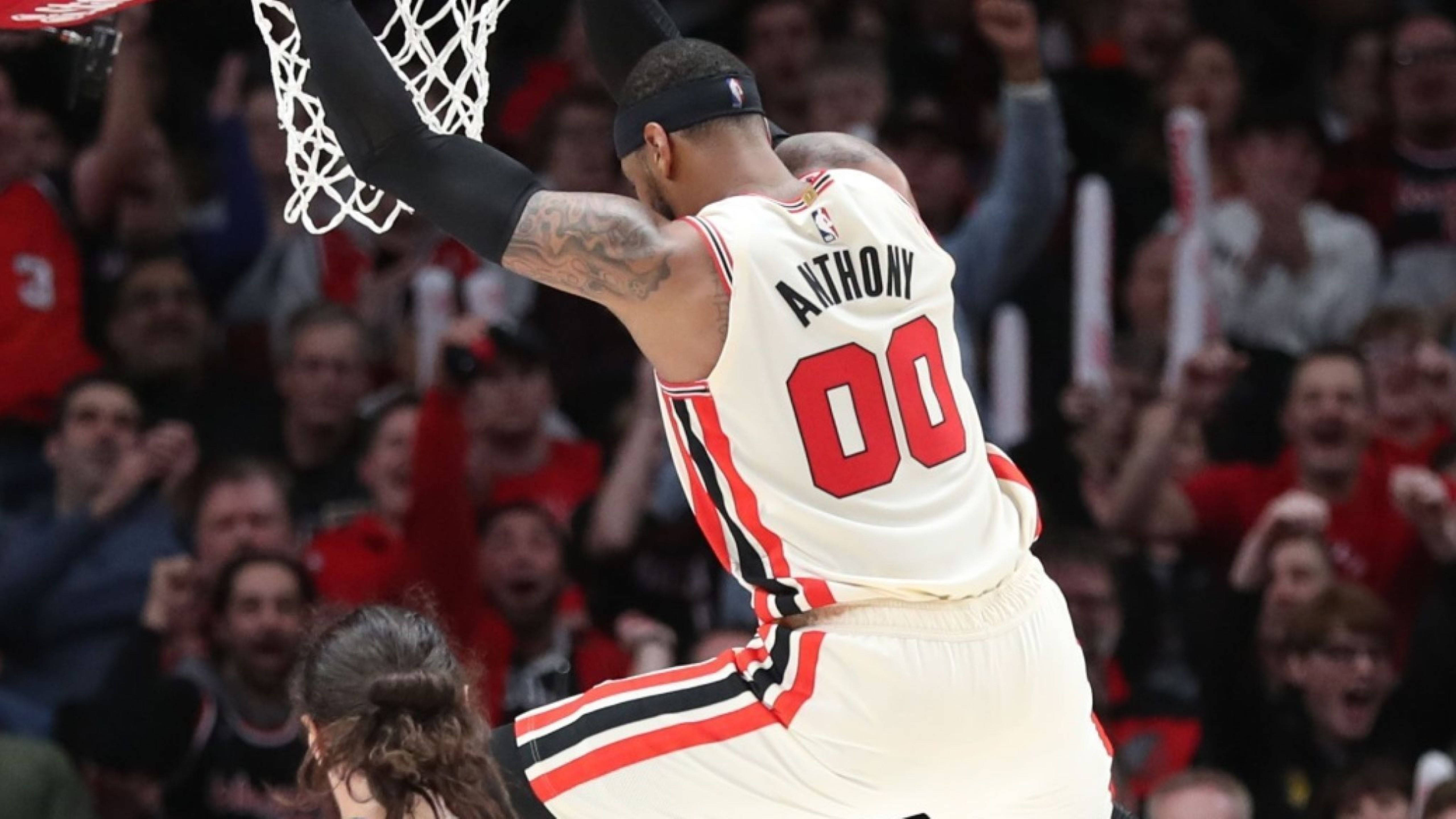 卡梅隆·安東尼NBA 00灌籃 壁紙 — 身穿白色球衣的籃球運動員安東尼在背景中歡呼的人群中灌籃。