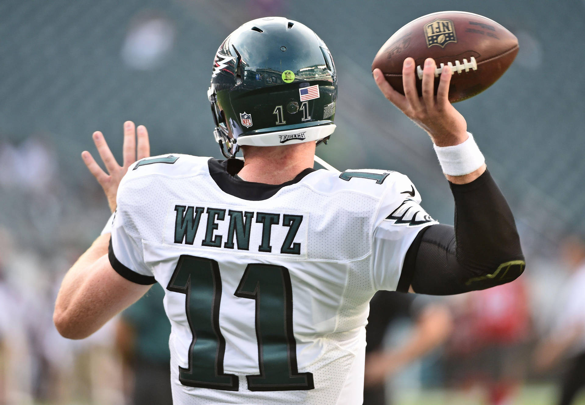 卡森·溫茲 NFL 投球瞬間 壁紙 — 四分衛 Carson Wentz 身穿白色 Eagles 球衣 11 號，在日間比賽中準備傳出橄欖球。