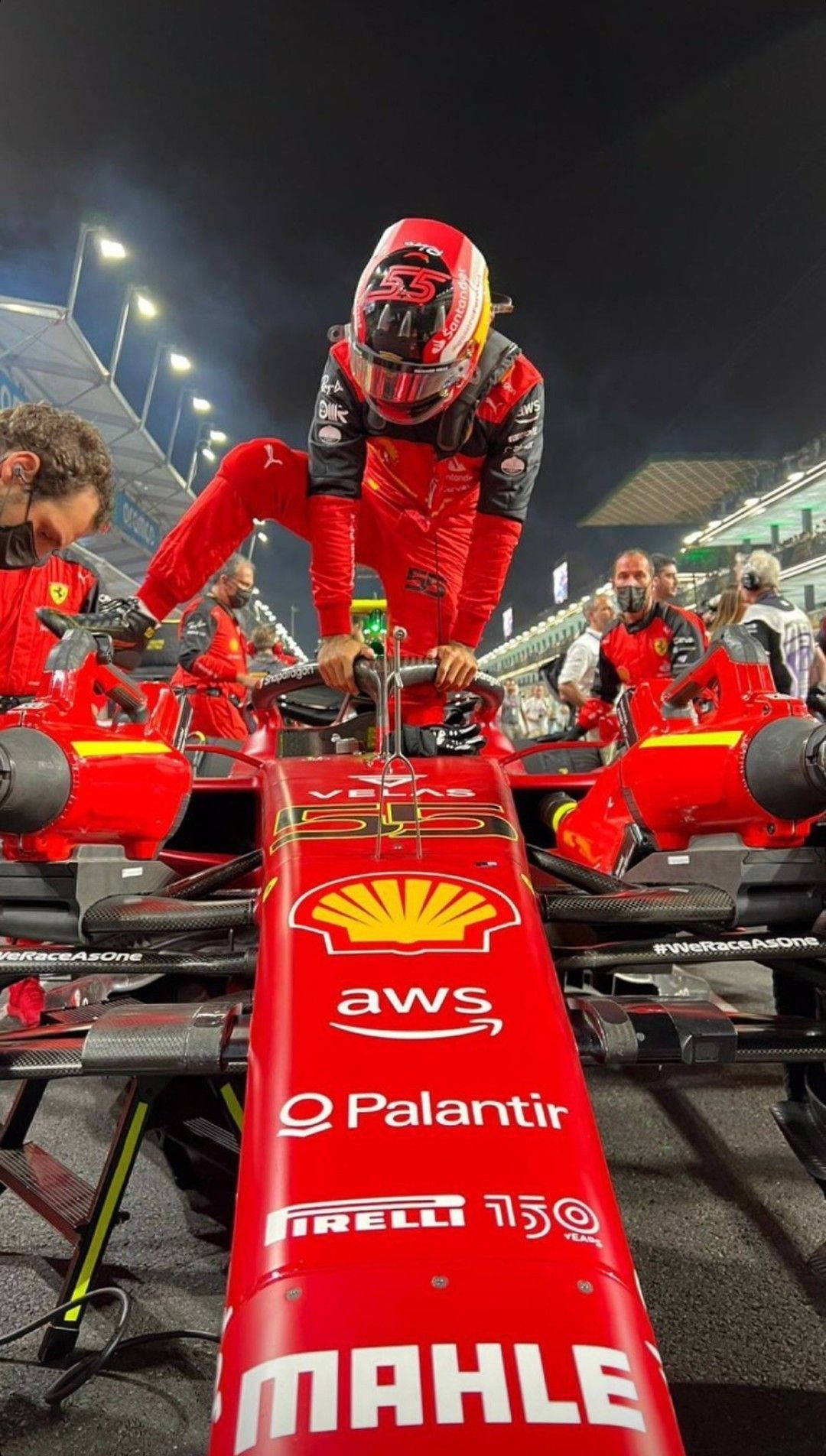 法拉利F1車手在夜間賽道進入他的賽車。
