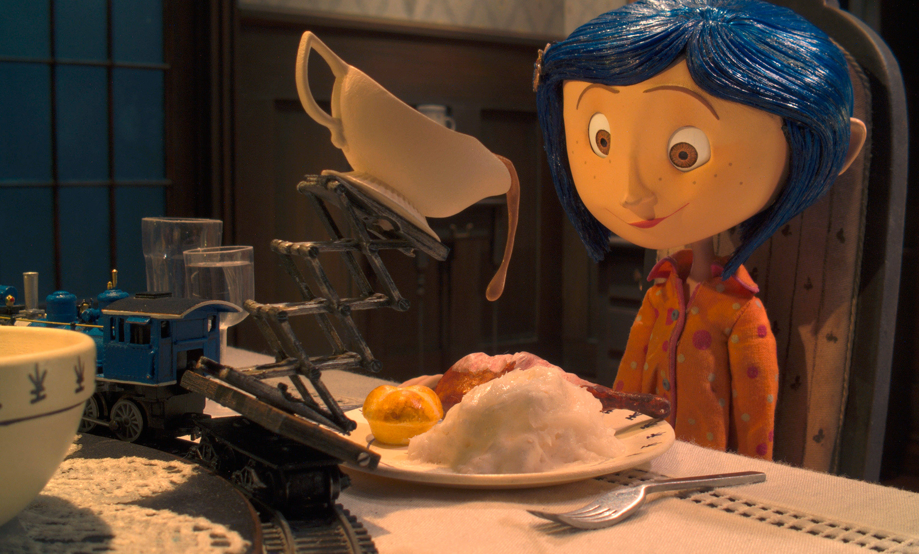 卡洛琳的早餐時光 壁紙 — 一個藍色頭髮嘅年輕女仔坐喺餐枱前，一架玩具火車將茶杯升起喺佢嘅早餐碟上面。