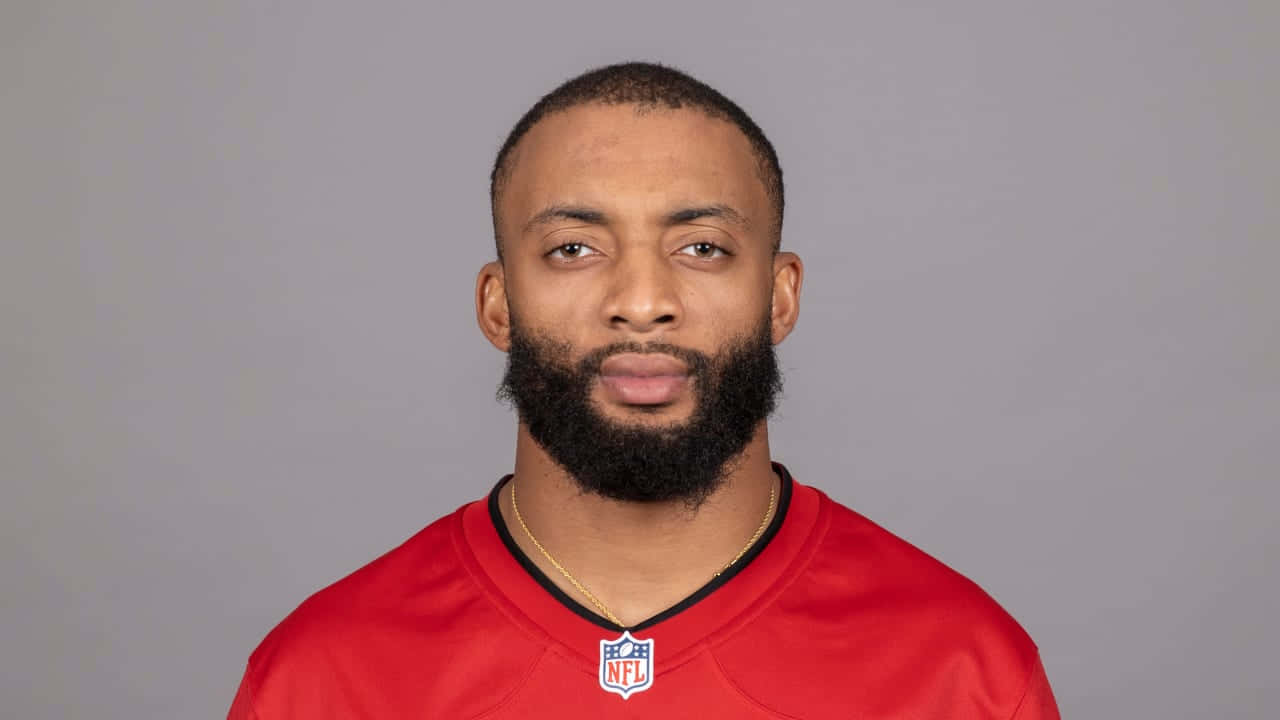 一位留鬍鬚的黑人足球員身穿紅色NFL球衣的肖像。