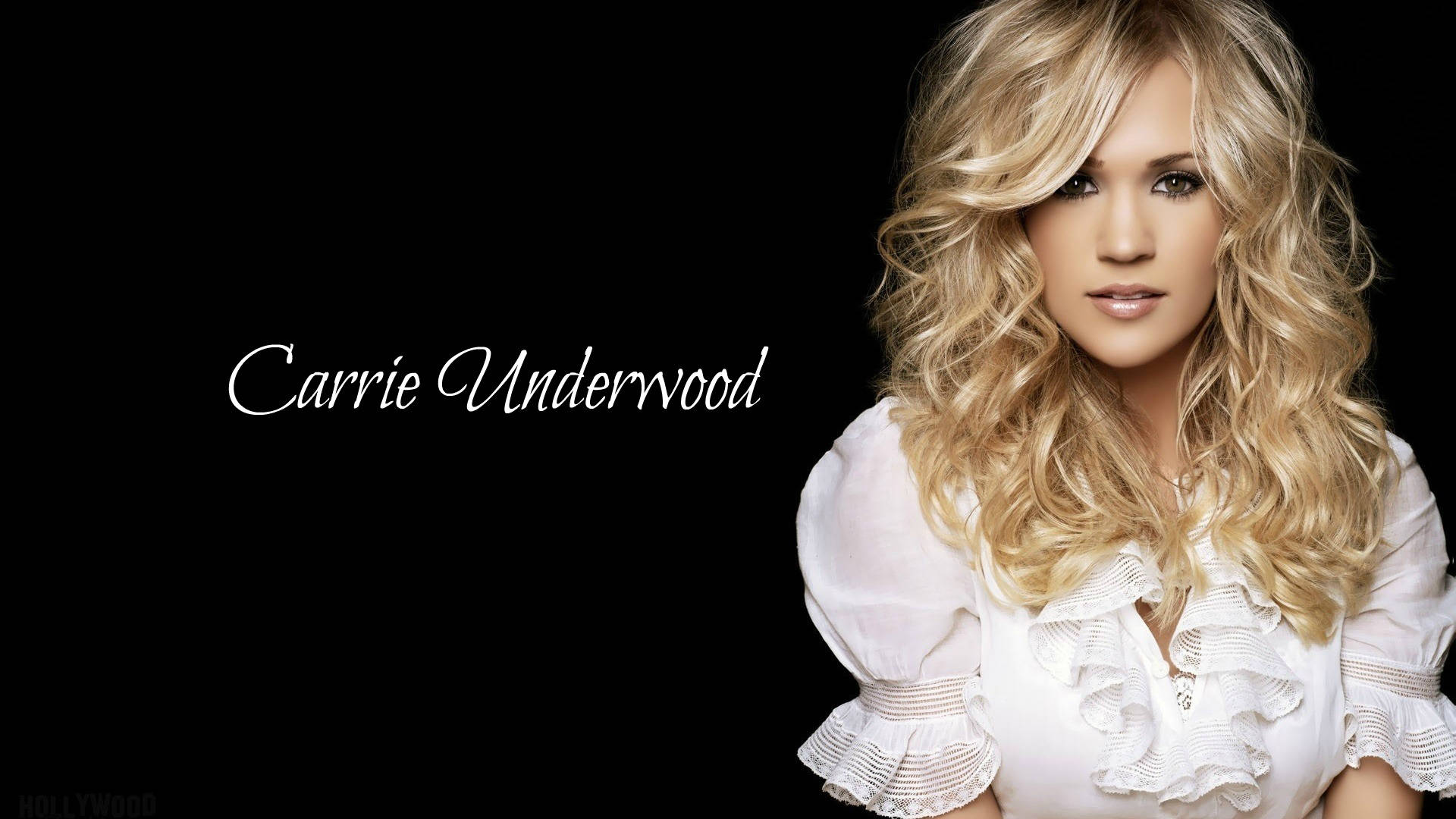 卡莉·厄本自然光采照人 壁紙 — Carrie Underwood 擁有豐盈的金色捲髮，穿著白色荷葉邊襯衫，在純黑背景下溫柔凝視。