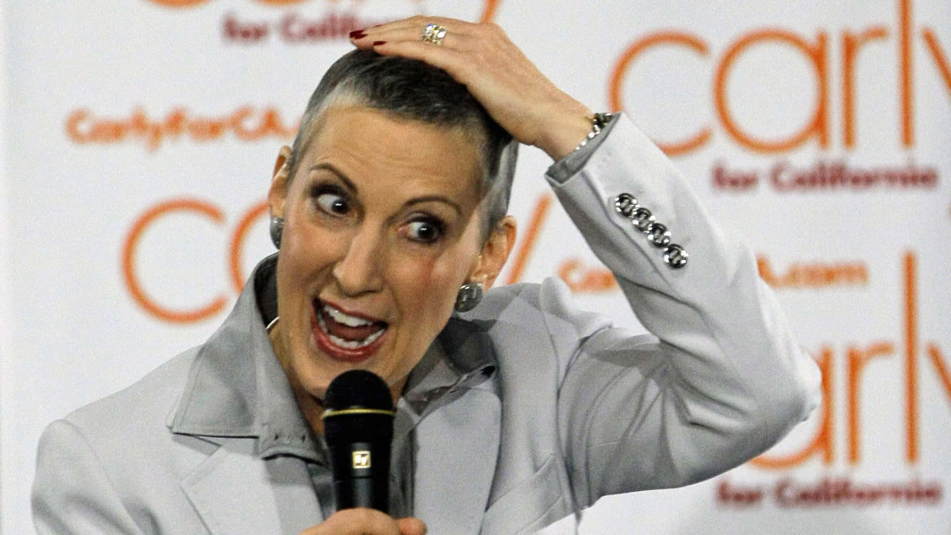 Carly Fiorina 在競選活動中說話，表情豐富，手放在頭上。
