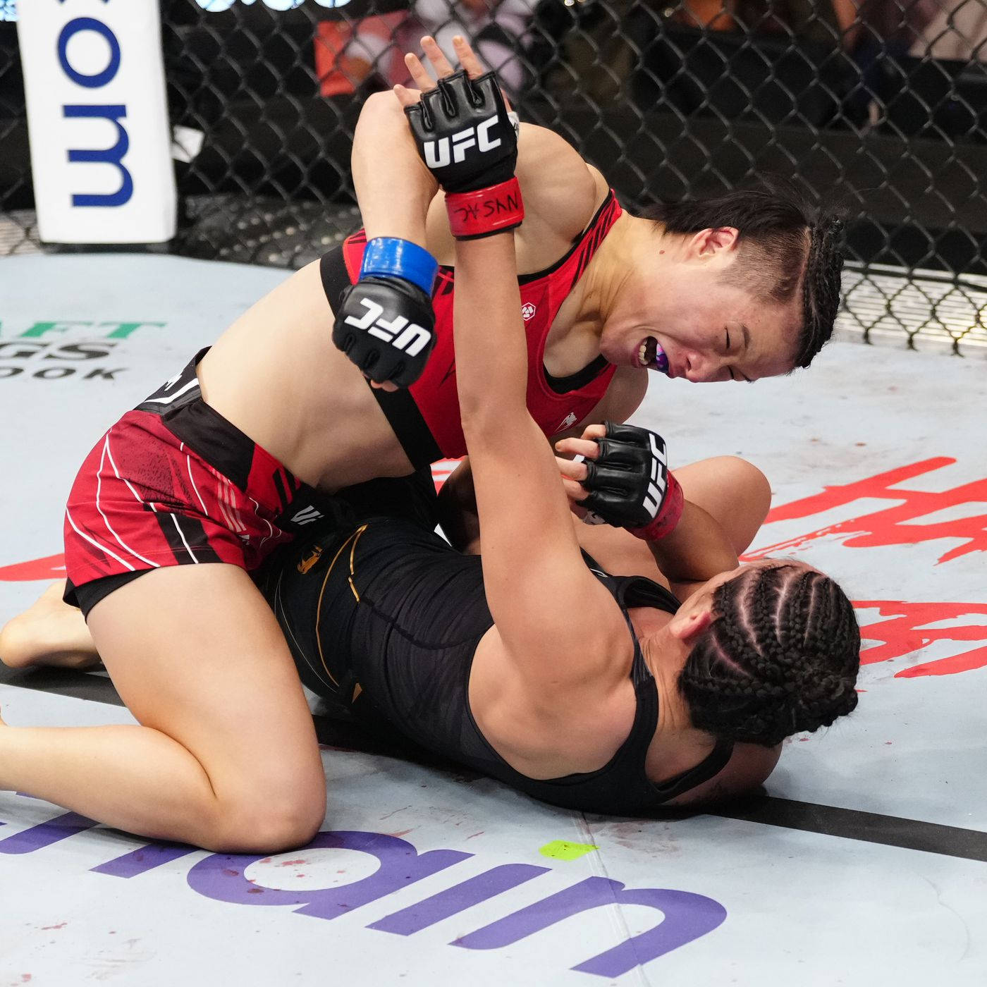 卡菈·艾斯帕薩被打倒 壁紙 — 兩名女性MMA拳手在UFC八角籠墊上激烈纏鬥，其中一人施展鎖喉技。