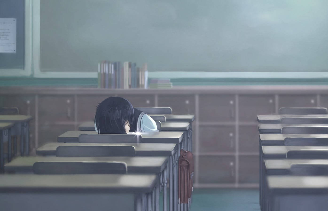 一個學生在空教室的書桌上睡覺。