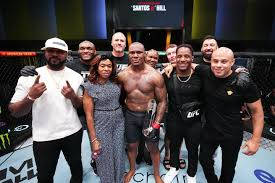 UFC拳手與團隊在八角籠內慶祝勝利。