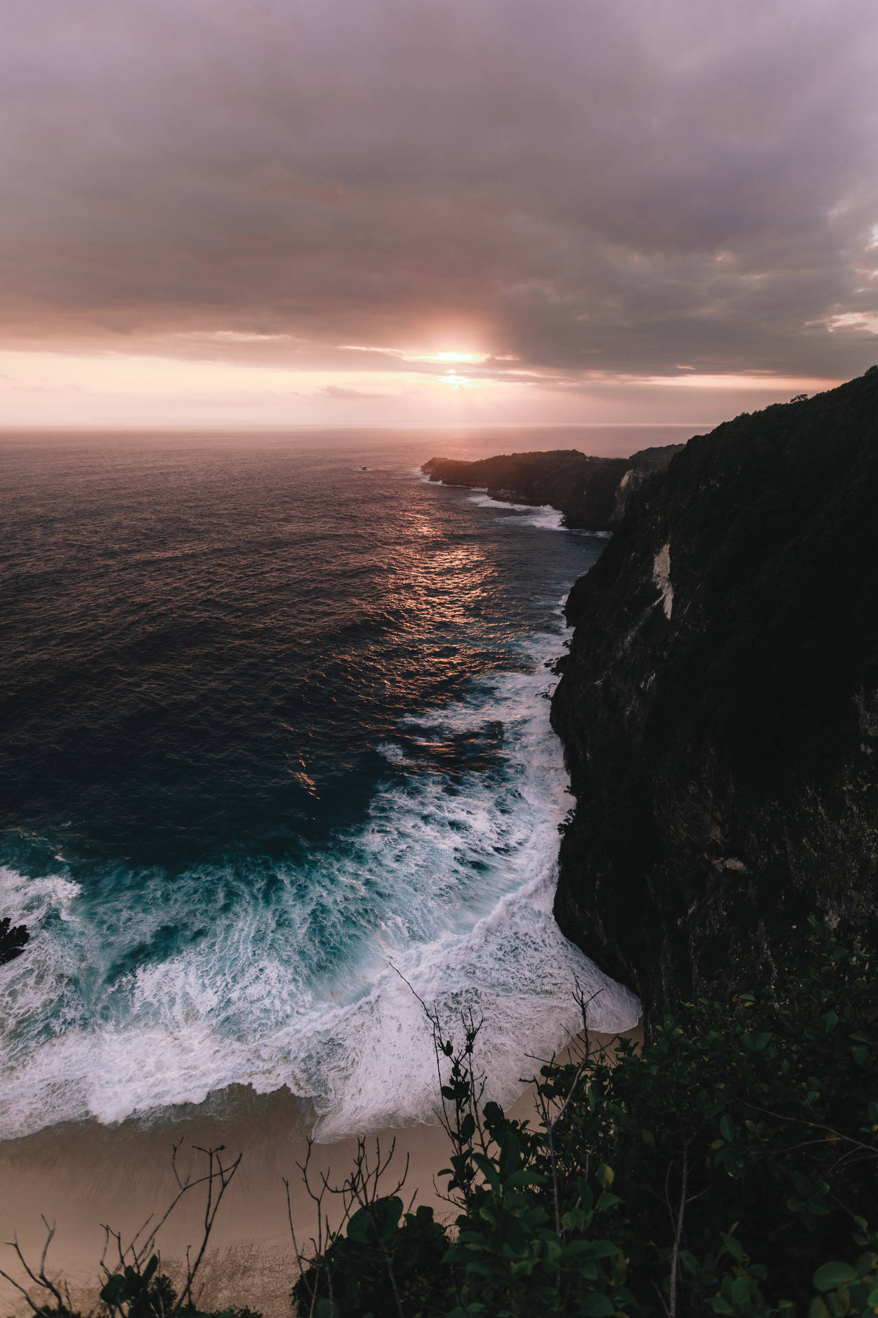 海洋上的夕陽，海浪拍打懸崖海灘