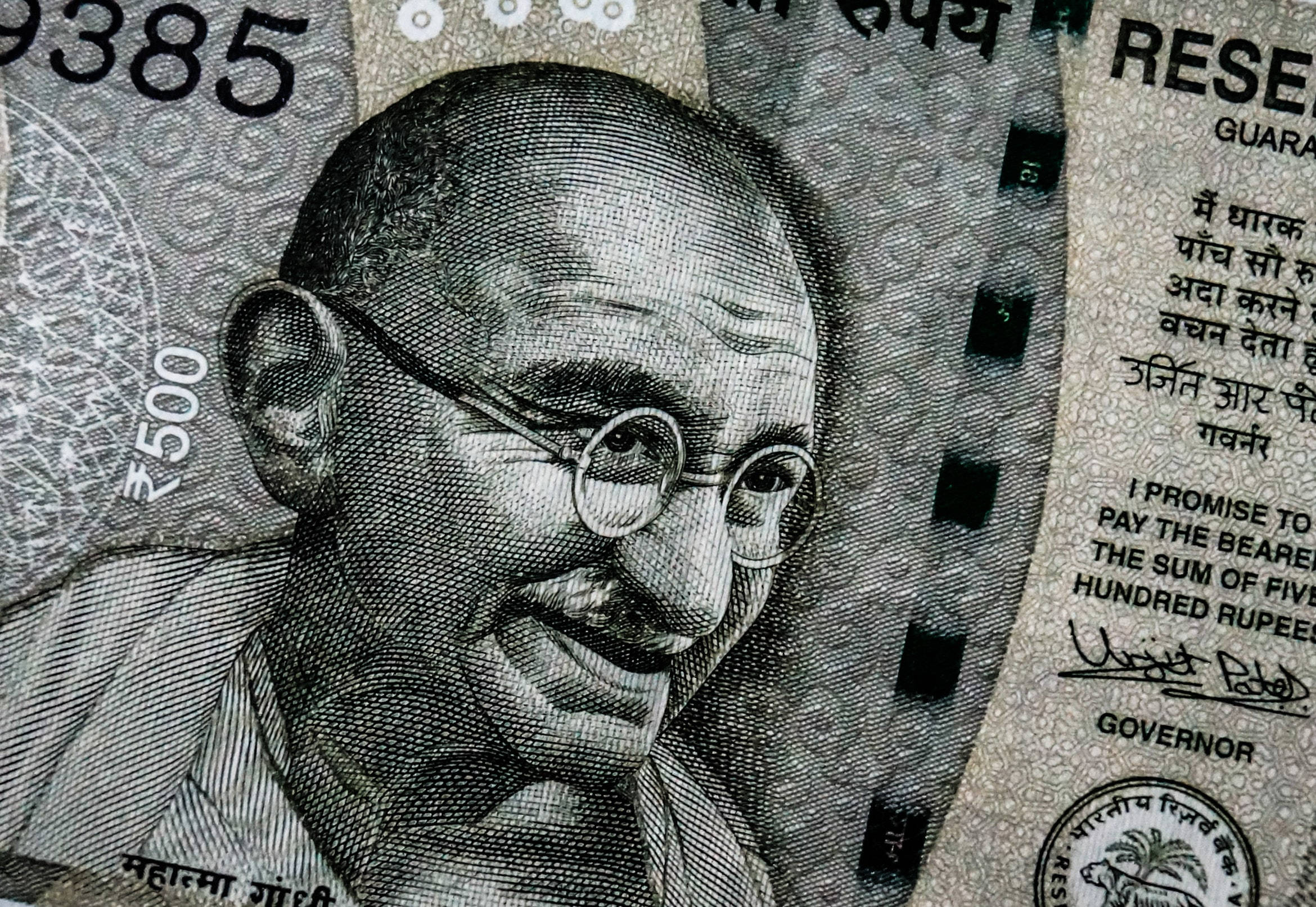 Indian 桌布 壁紙 — 印度500盧比紙幣上聖雄甘地微笑肖像的特寫，帶有複雜的安全圖案和文字。
