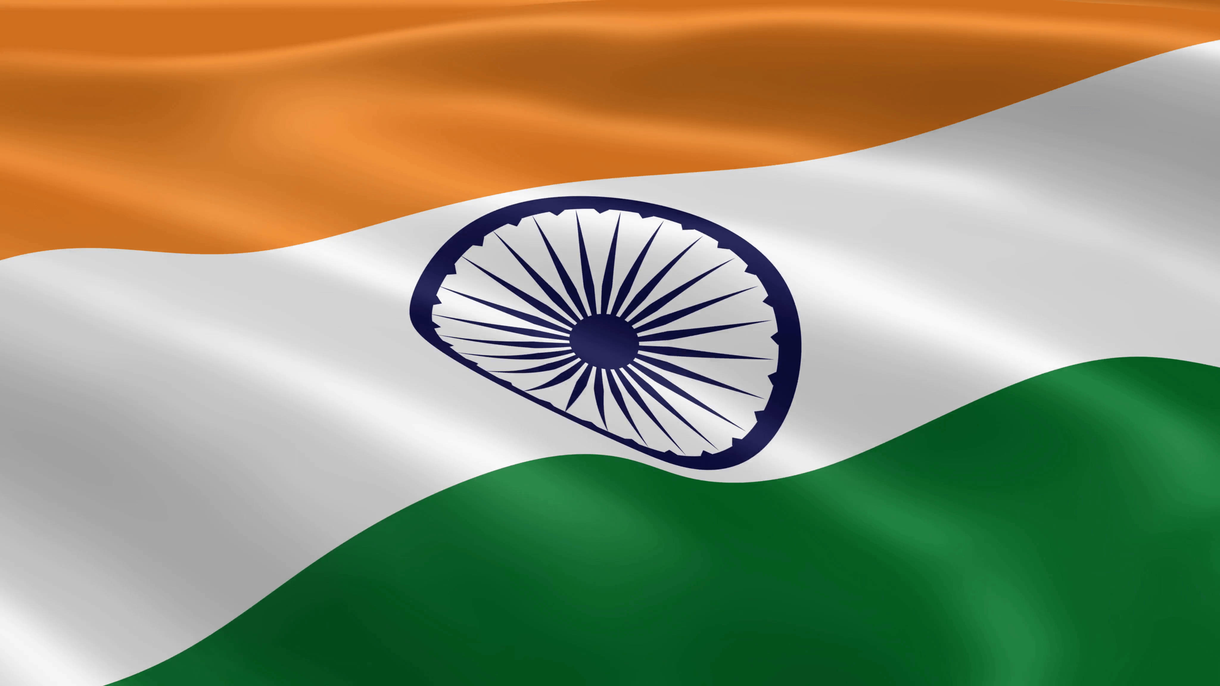 India 桌布 壁紙 — 印度國旗動態飄揚，帶有鮮豔的藏紅花、白色和綠色條紋，中央是海軍藍色的阿育王法輪。