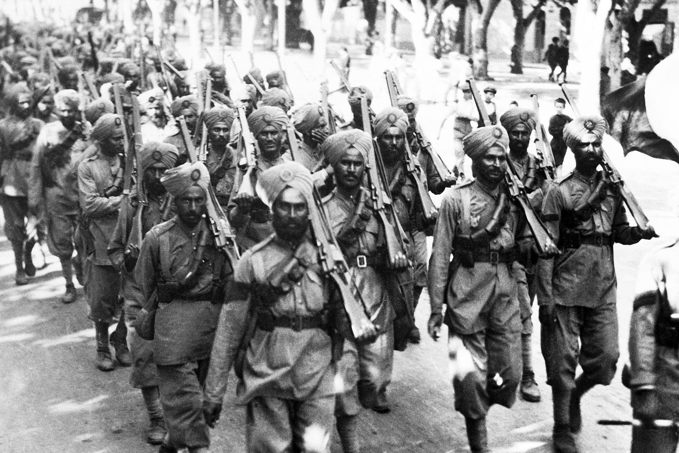 Indian Army 桌布 壁紙 — 印度士兵戴頭巾持步槍沿林蔭大道列隊行進的黑白照片。