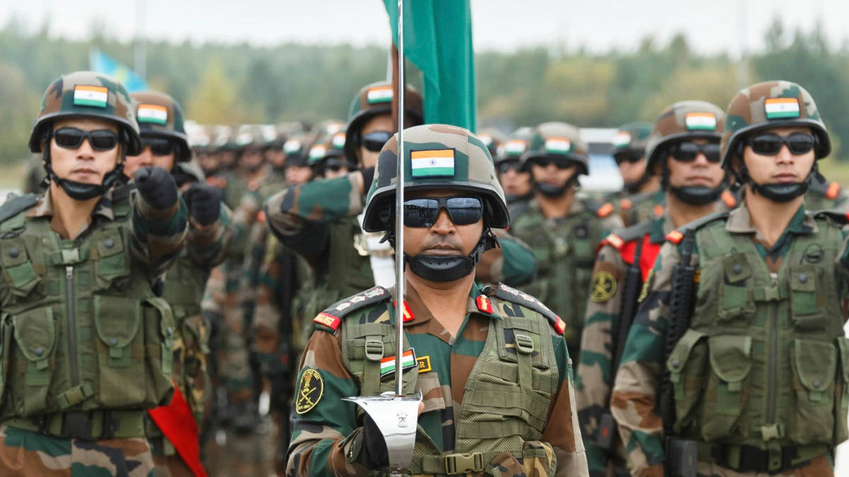Indian Army 桌布 壁紙 — 印度士兵身穿迷彩服和頭盔，手持國旗，在戶外軍事閱兵中列隊。
