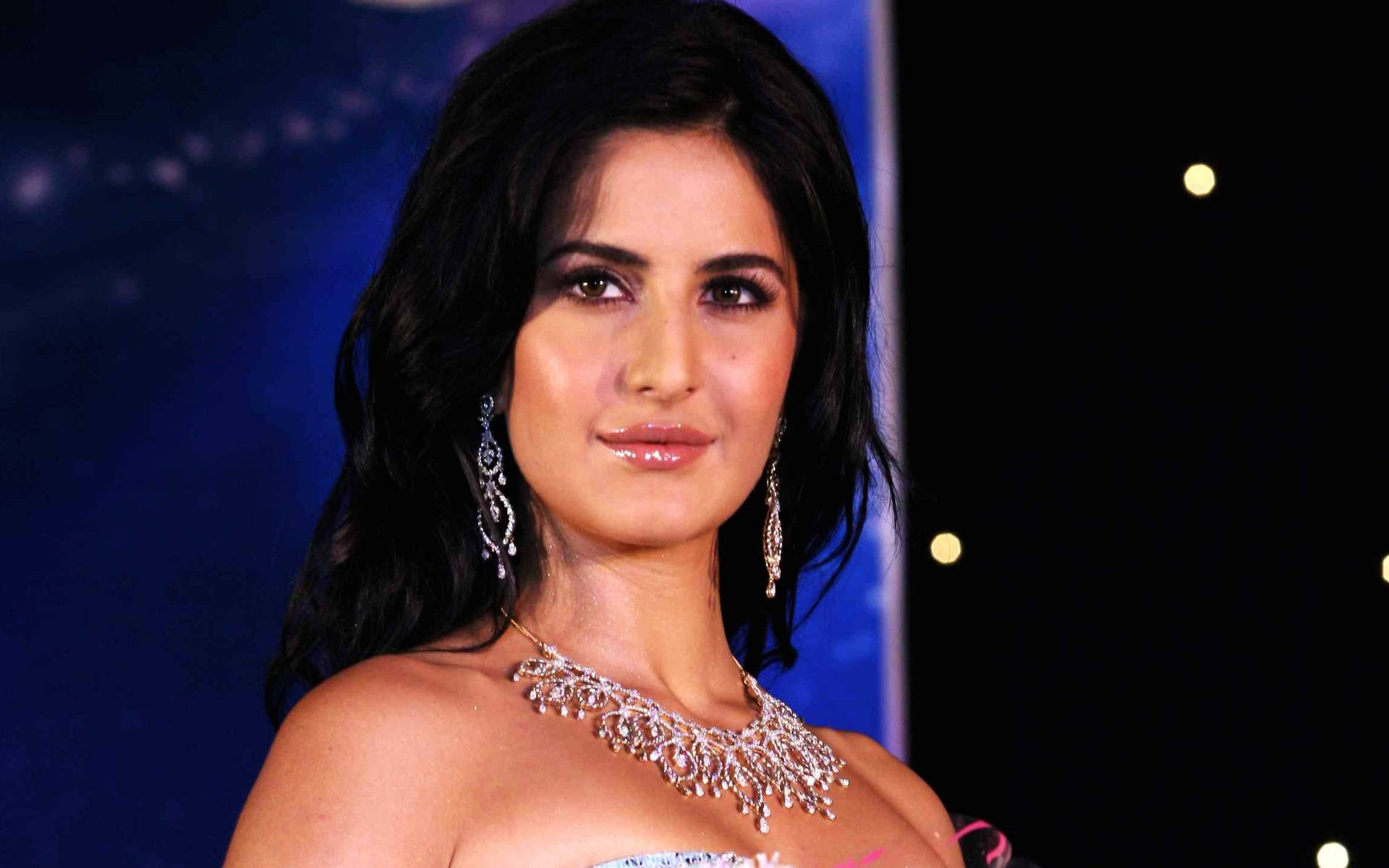 印度女演員卡特里娜·凱芙 壁紙 — Katrina Kaif 在深藍色星空背景下，戴著閃閃發光的鑽石項鍊和耳環，優雅地微笑。