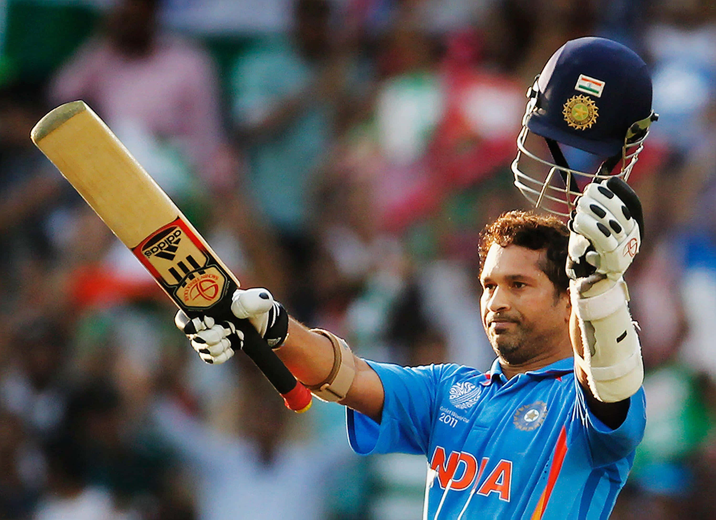 Sachin Tendulkar 桌布 壁紙 — 印度板球運動員在體育場人群中高舉球棒和頭盔慶祝勝利。