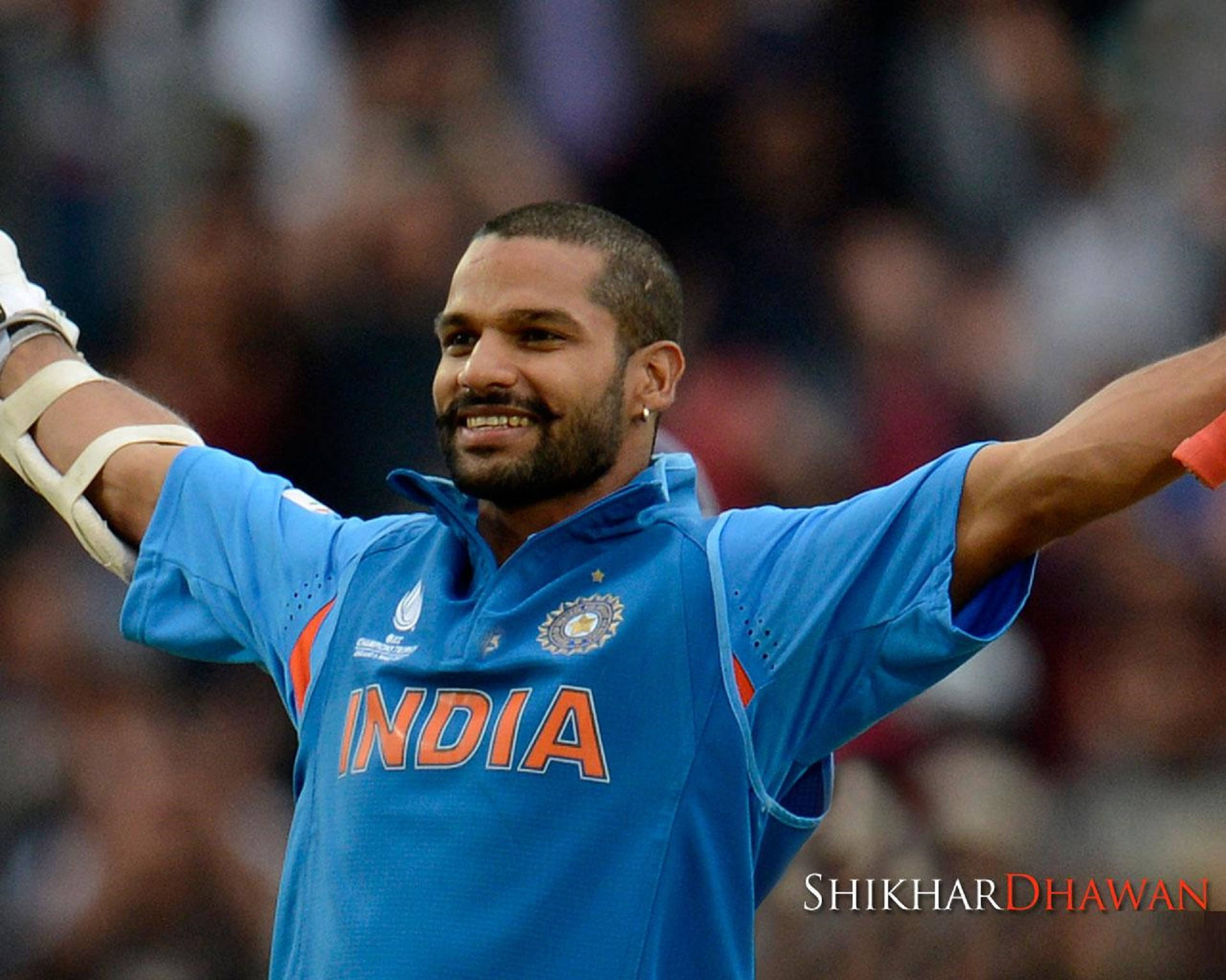 印度板球運動員 Shikhar Dhawan 在體育場高舉雙臂慶祝勝利。